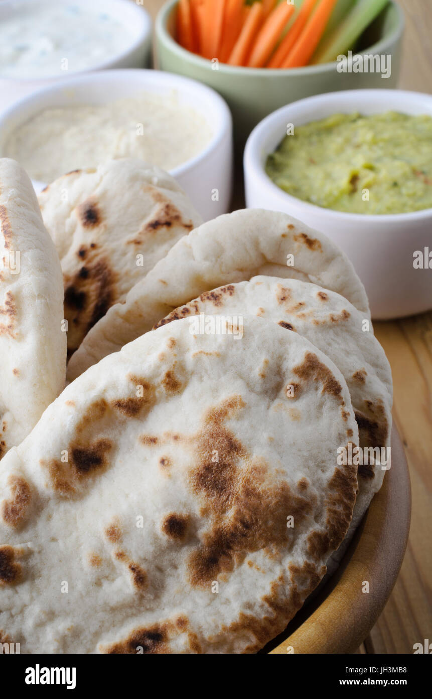 Tabelle mit einem frische vegetarische Buffet mit Pitta-Brot und eine Auswahl an Dips mit Crudites in Schälchen gelegt. Stockfoto