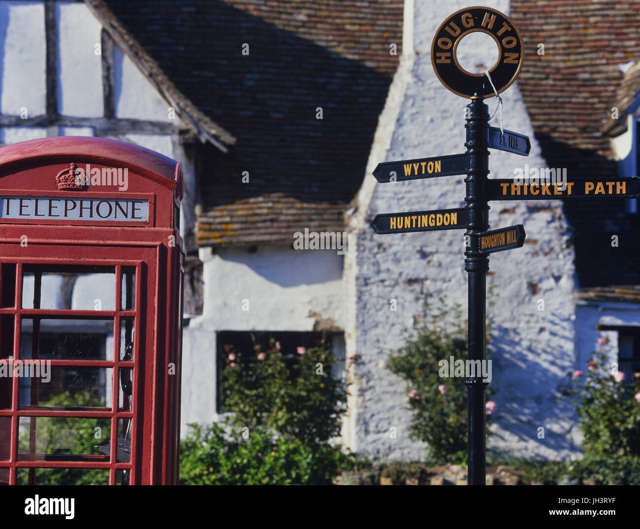 Wegweiser und rote Telefonzelle box in Houghton Dorf, Cambridgeshire, England, UK Stockfoto