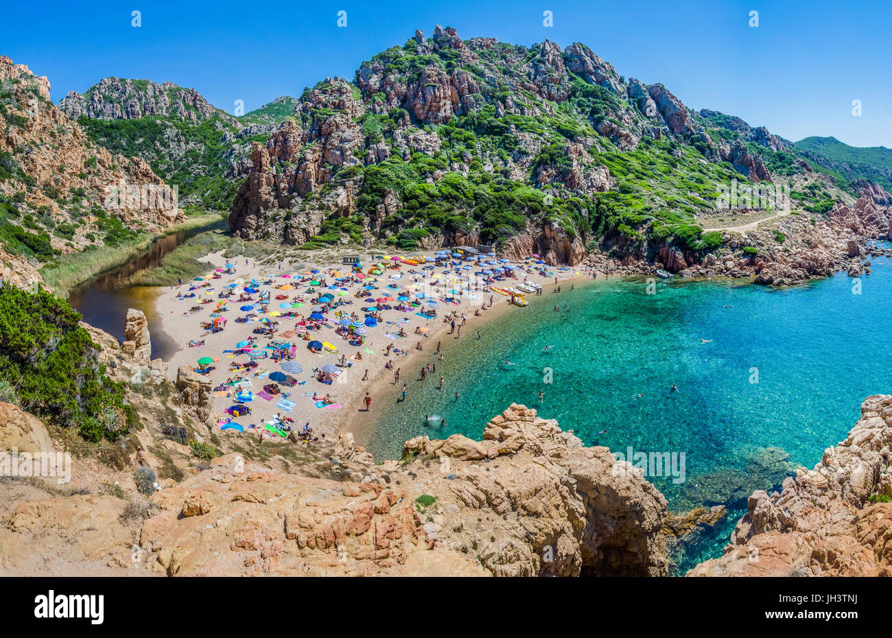 Touristen, die bunte Sonnenschirme am Costa Paradiso Beach, Sardinien, Italien. Stockfoto