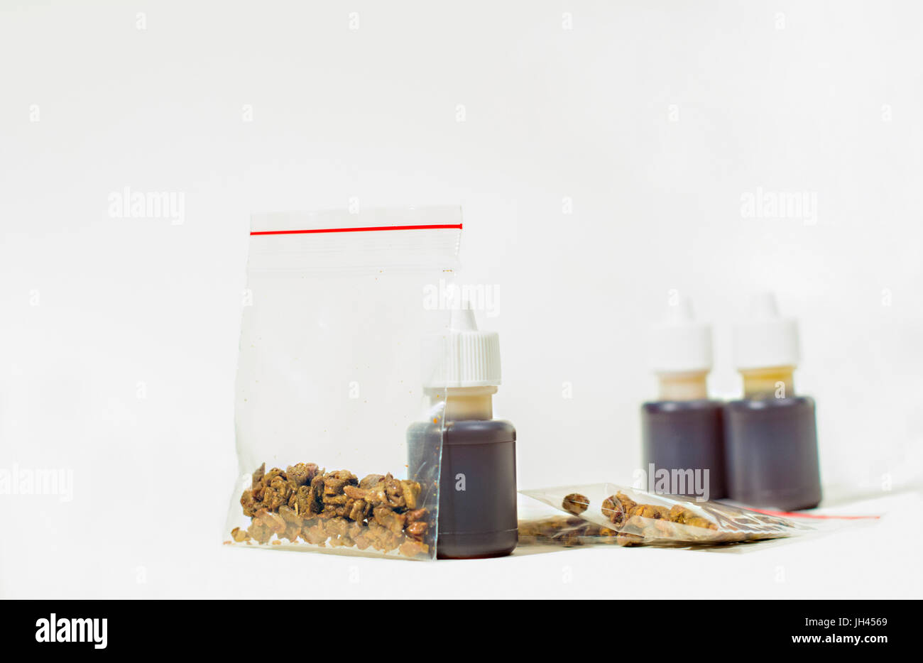Propolis... Rohe Propolis in verschließbaren Taschen und Lösung von Propolis in kleinen Flaschen. Stockfoto