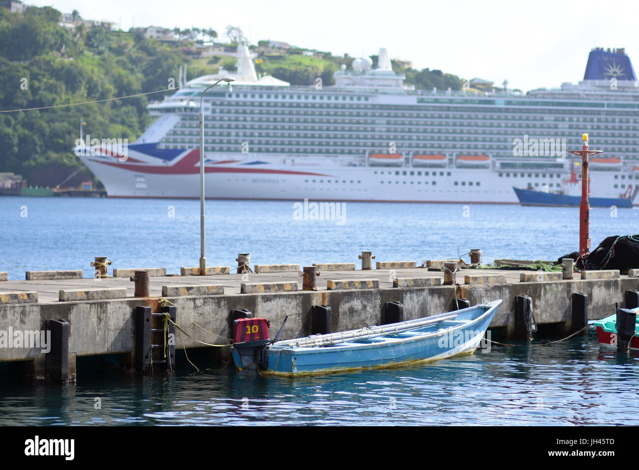 P & O Kreuzfahrt Schiff MV Britannia angedockt in Kingstown, St. Vincent & die Grenadinen in der Karibik, mit kleinen lokalen Boot im Vordergrund Stockfoto