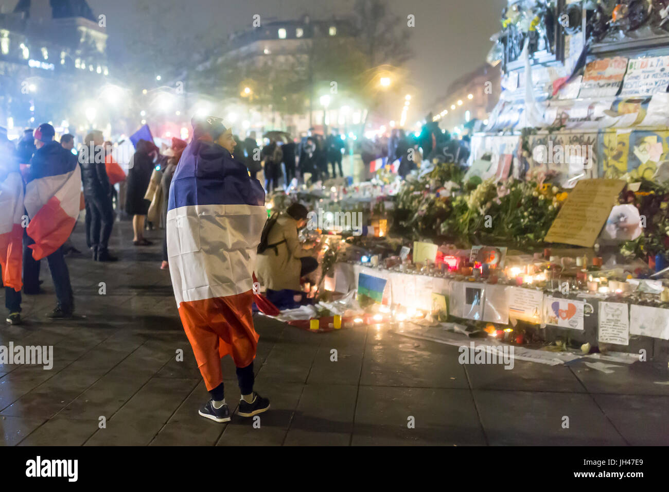 Ein Mann mit der französischen Flagge. Spontane Hommage an die Opfer der Terroranschläge in Paris 13. November 2015 Stockfoto