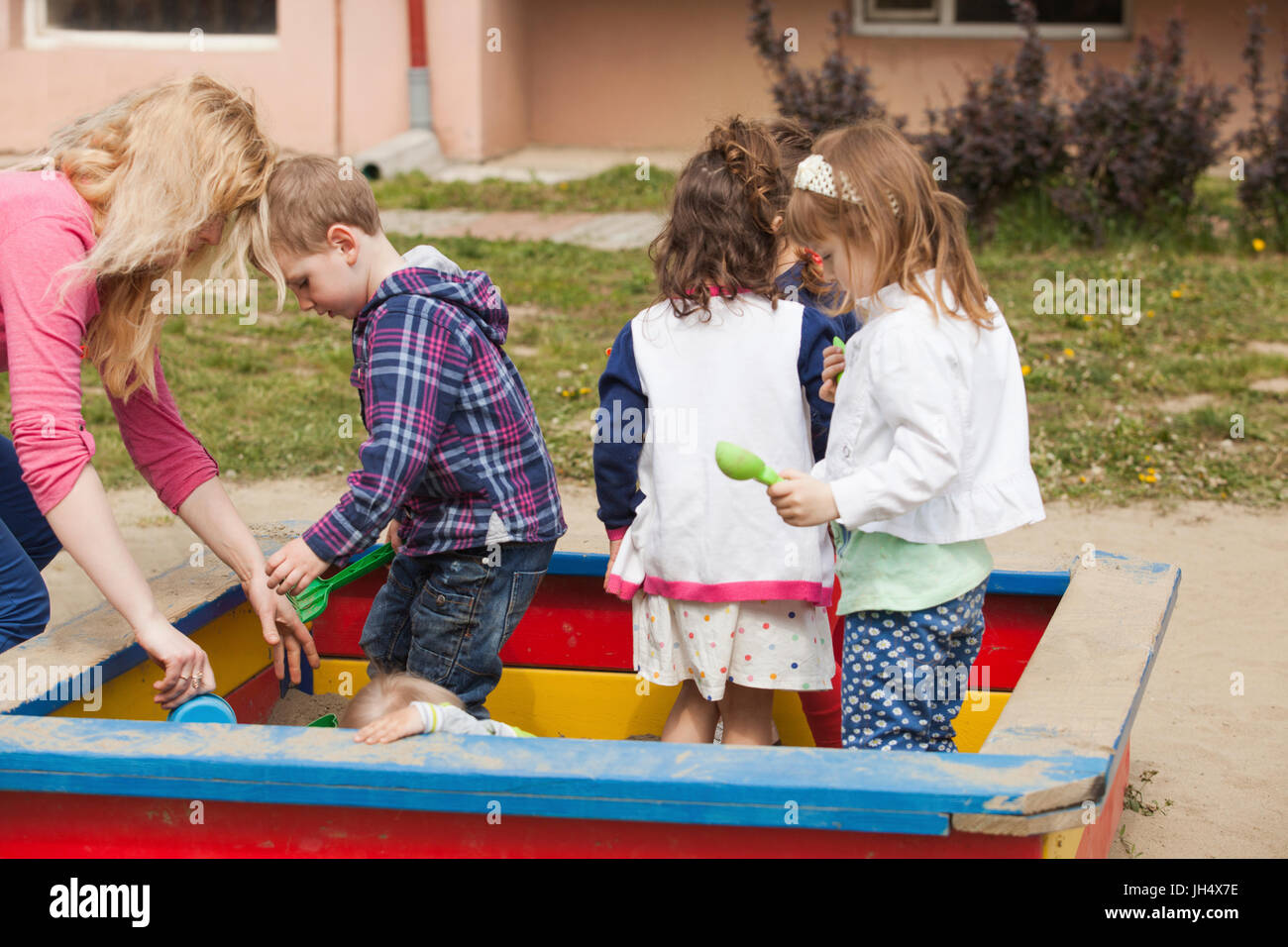 Kinder sind auf dem Spielplatz mit Sand im Sandkasten spielen. Stockfoto