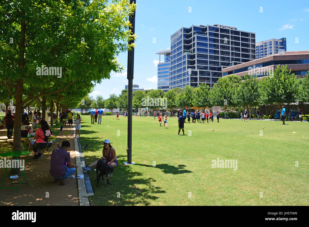 Bewohner zu entkommen die Mitte Tag Hitze im Schatten der Eichen im Klyde Warren Deck Park in der Innenstadt von Dallas Texas Stockfoto