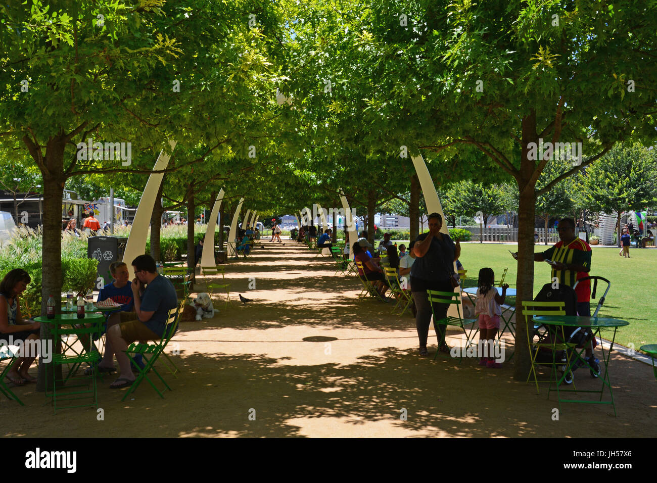 Bewohner zu entkommen die Mitte Tag Hitze im Schatten der Eichen im Klyde Warren Deck Park in der Innenstadt von Dallas Texas Stockfoto