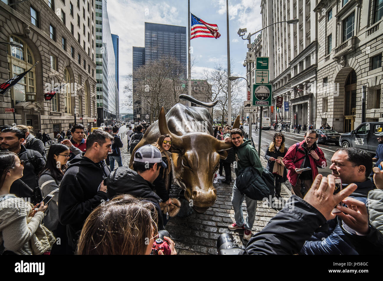 New York, USA - ca. März 2016 - Touristen berühren des Wall-Street-Stiers Stockfoto