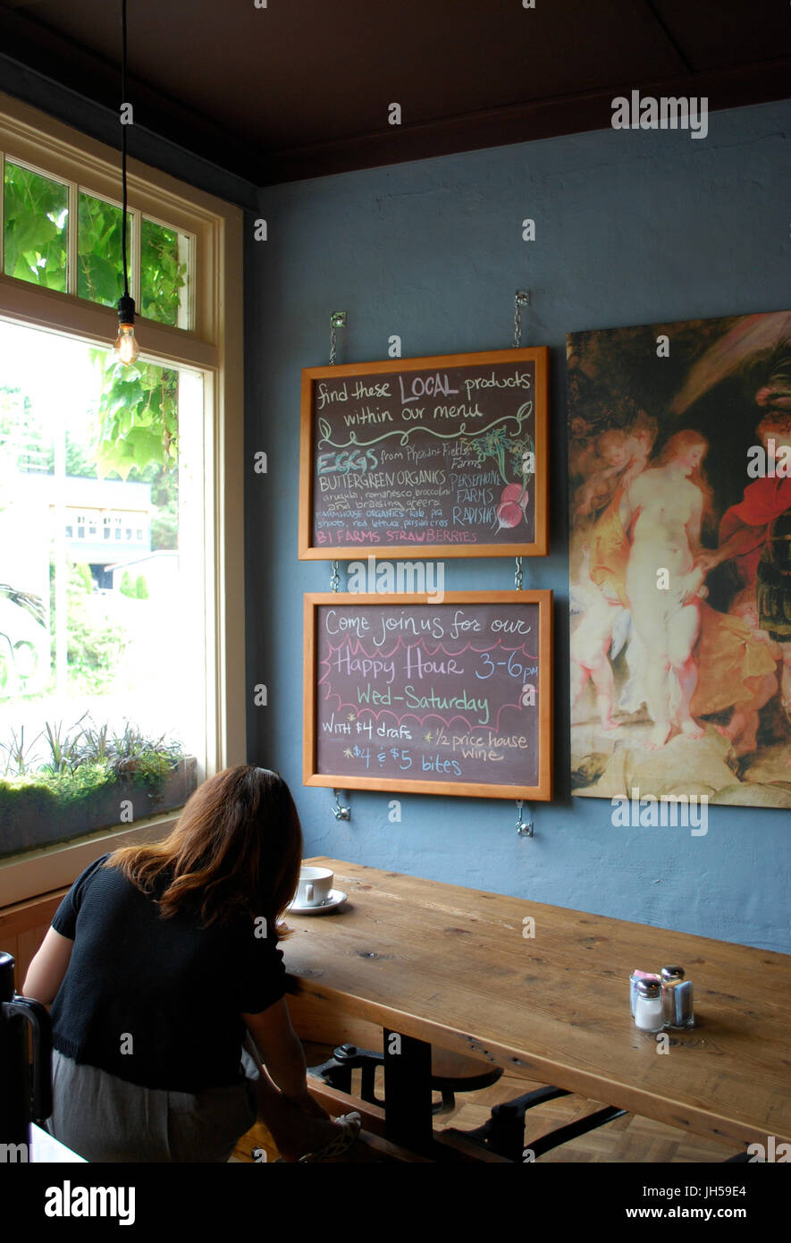 Frau, sitzen, Kaffeetrinken im Pegasus Coffee House, Bainbridge Island, WA. USA Stockfoto