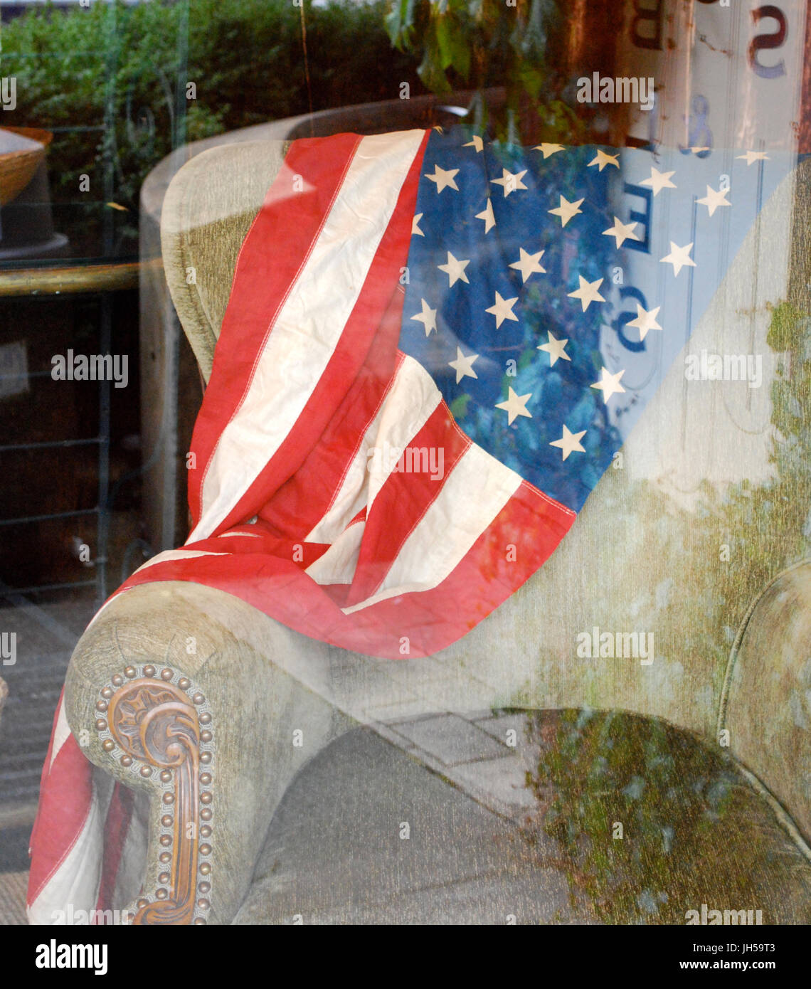 Amerikanische Flagge drapiert über einen Vintage Stuhl - vierten Juli Schaufenster Bainbridge Island, WA. USA Stockfoto