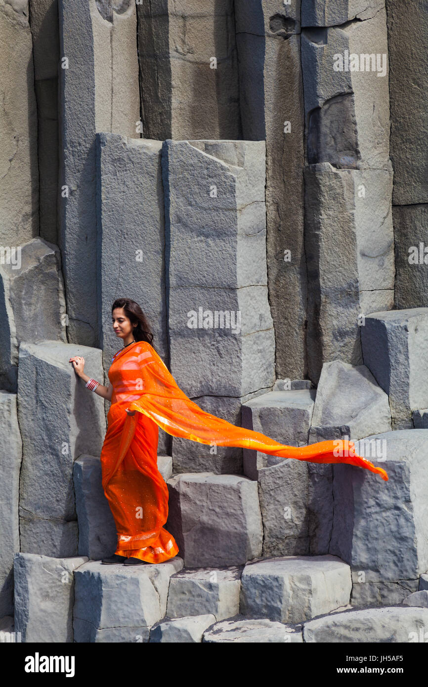 Indische Frau posiert auf die Basaltsäulen am Reynisfjara Beach in Island Stockfoto