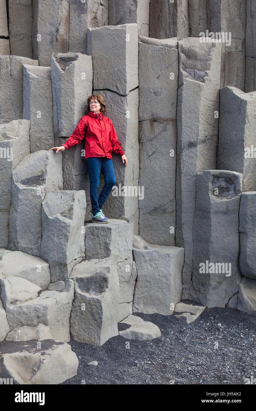 Touristischen posiert auf dem großen Basaltsäulen am Reynisfjara Beach in Island Stockfoto