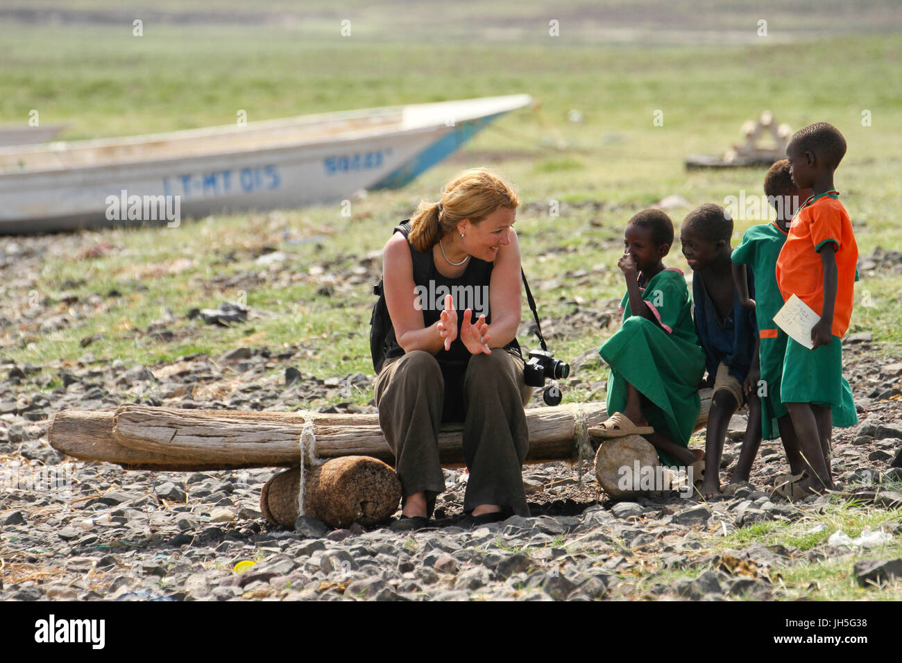 LOIYANGELENI, Kenia - Mai 18.. Ein Tourist plaudert mit Kindern am Ufer des Lake Turkana während des Lake Turkana-Festivals. Bildnachweis: David Mbiyu/Alamy Live-Nachrichten Stockfoto