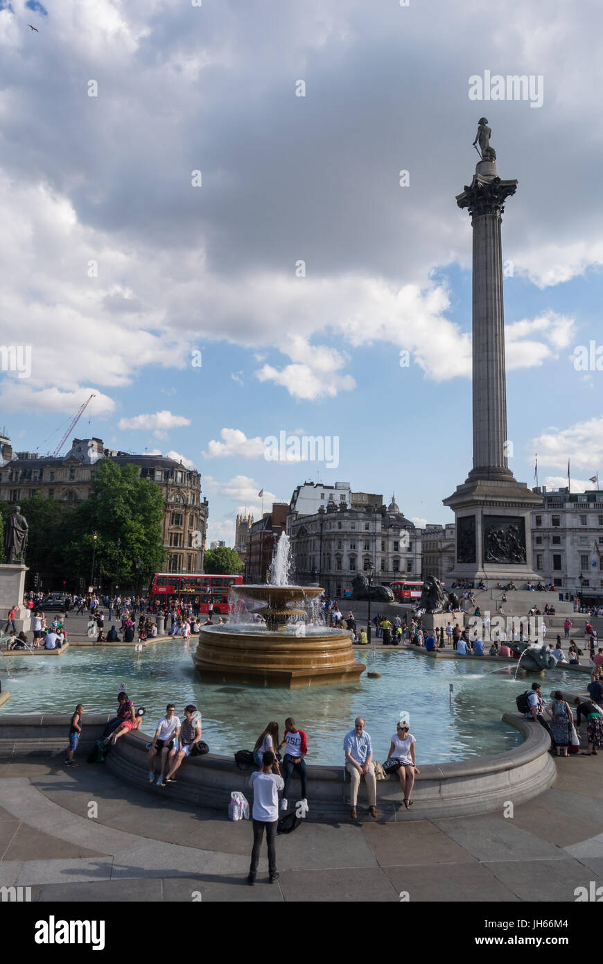 Touristen versammeln sich am Trafalgar-Platz mit der Nelsons-Säule im Hintergrund Stockfoto