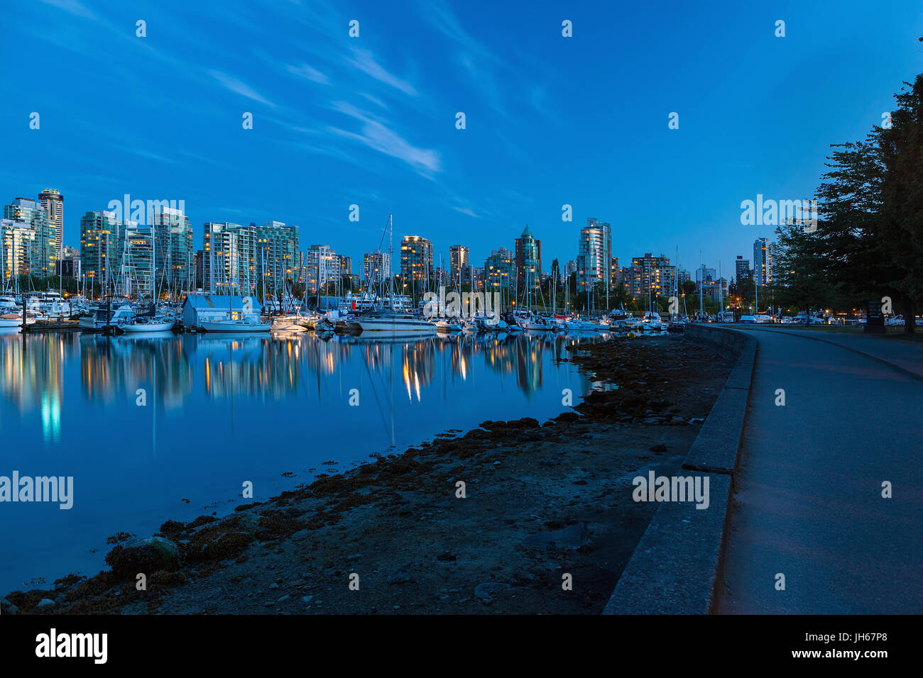 Skyline von Vancouver British Columbia Kanada am Yachthafen entlang Stanley Park Ufermauer am Abend blaue Stunde Stockfoto