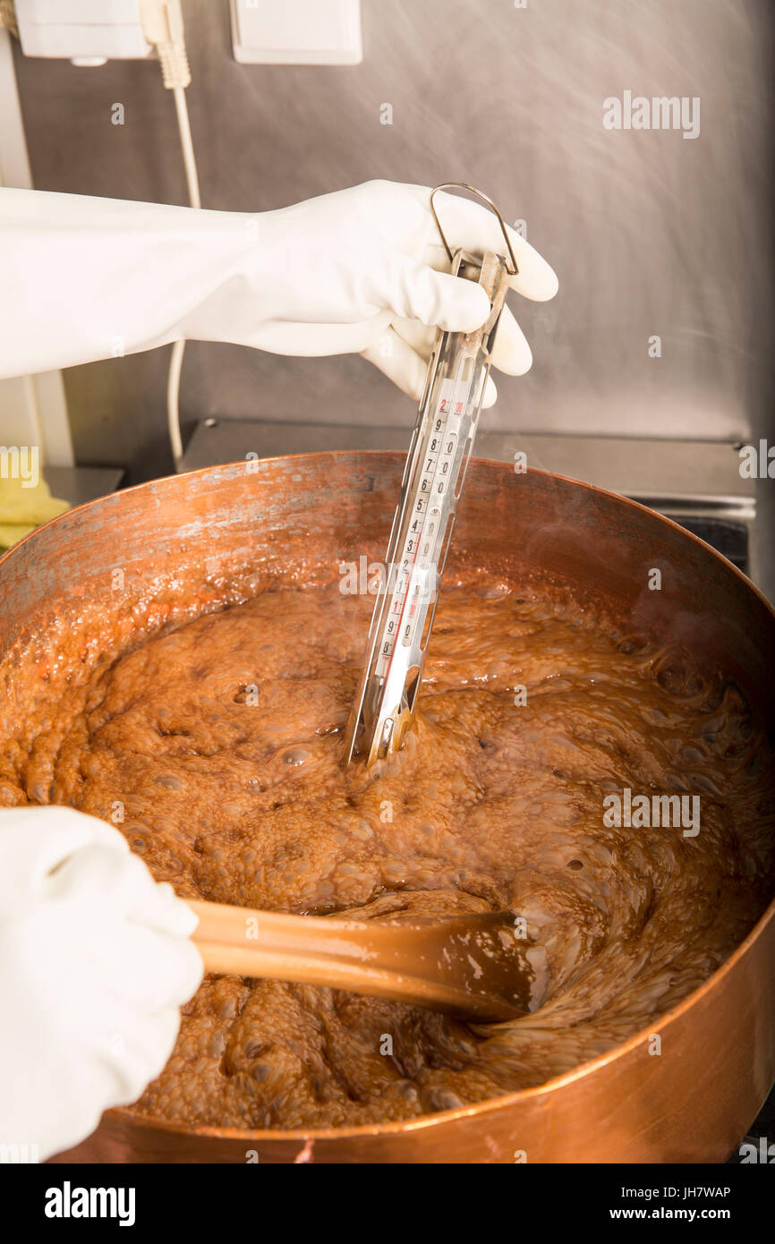 Fabrik für die Herstellung von leckeren Karamell Bonbons. Der erste  Schritt. Kochenden Sirup aus Zucker im Kupferkessel mit Thermometer und  großen Löffel. Braune Farbe Stockfotografie - Alamy