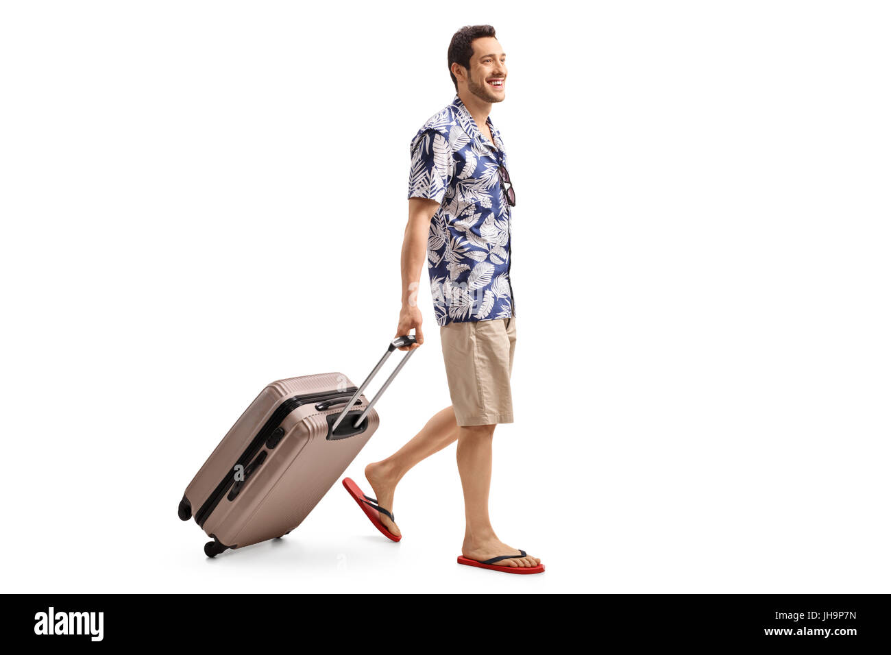 Voller Länge Profil Schuss eines Touristen zu Fuß und ziehen einen Koffer isoliert auf weißem background.jpg Stockfoto