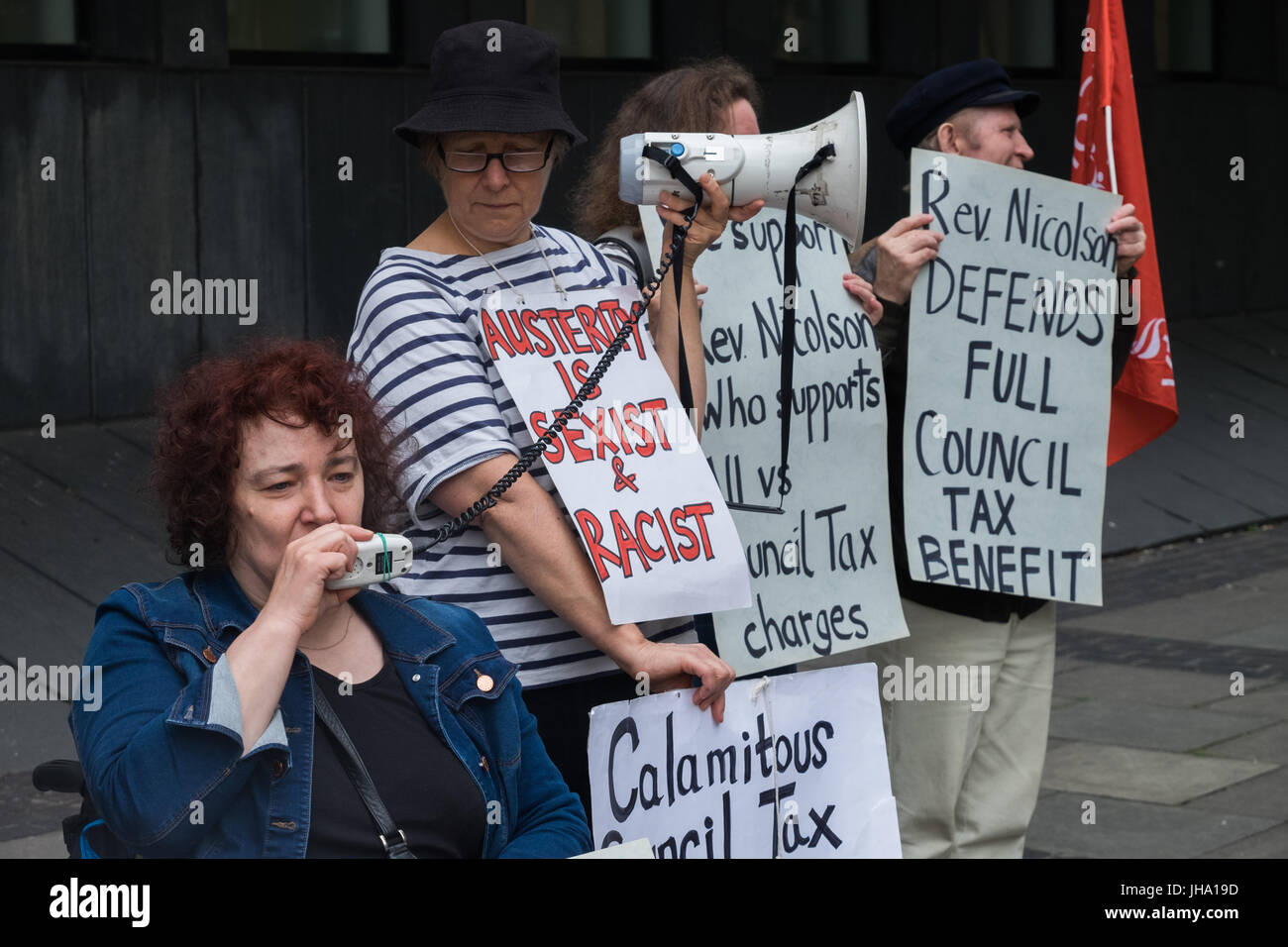 London, UK. 13. Juli 2017. Anhänger protestieren außerhalb Highbury Corner Magistrates Court wo Rev Paul Nicolson der Steuerzahler gegen Armut beschworen wird, erscheinen nach seiner Weigerung, Gemeindesteuer in Solidarität mit allen im Königreich zu zahlen leiden geistigen oder körperlichen Erkrankungen aufgrund von unzureichenden Einkommen und Schulden. Claire Glasman von WInvisible spricht zur Unterstützung seiner Kampagne sprach er später auf den Druck der Kürzungen auf die Armen, die dringend für Nahrung, Kraftstoff, Kleidung, Transport zahlen müssen und erinnerte uns an die vergessene ethisches Prinzip "Land ist ein Geschenk der Natur existiert, Shel bieten Stockfoto