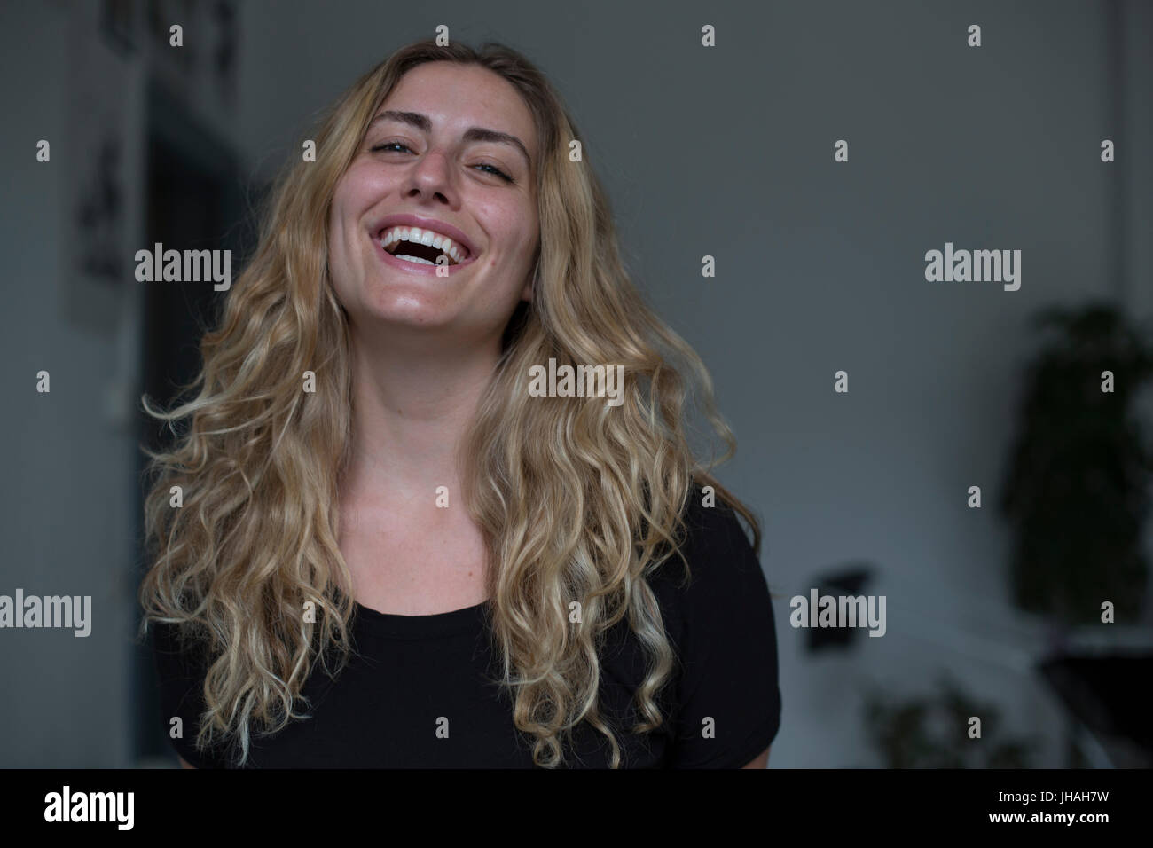 Jung, kaukasischen, blonde schöne Frau Blickkontakt mit Kamera während lächelnd, Glück in Richtung des Betrachters zum Ausdruck zu bringen. Weiche, natürliche Beleuchtung Stockfoto