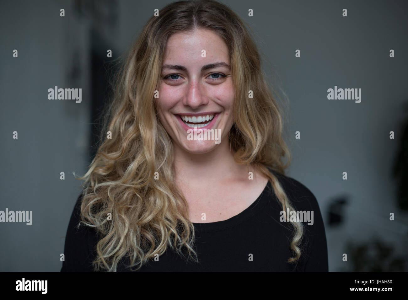 Jung, kaukasischen, blonde schöne Frau Blickkontakt mit Kamera während lächelnd, Glück in Richtung des Betrachters zum Ausdruck zu bringen. Weiche, natürliche Beleuchtung Stockfoto