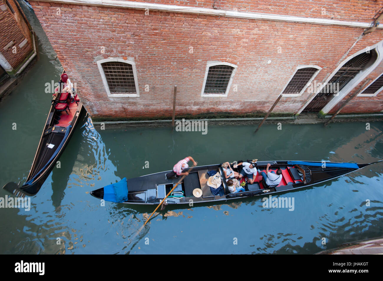 Venedig - zwei Gondeln mit Touristen, die von oben gesehen folgen einander in einem engen Kanal in das Sestiere San Marco Bereich Stockfoto