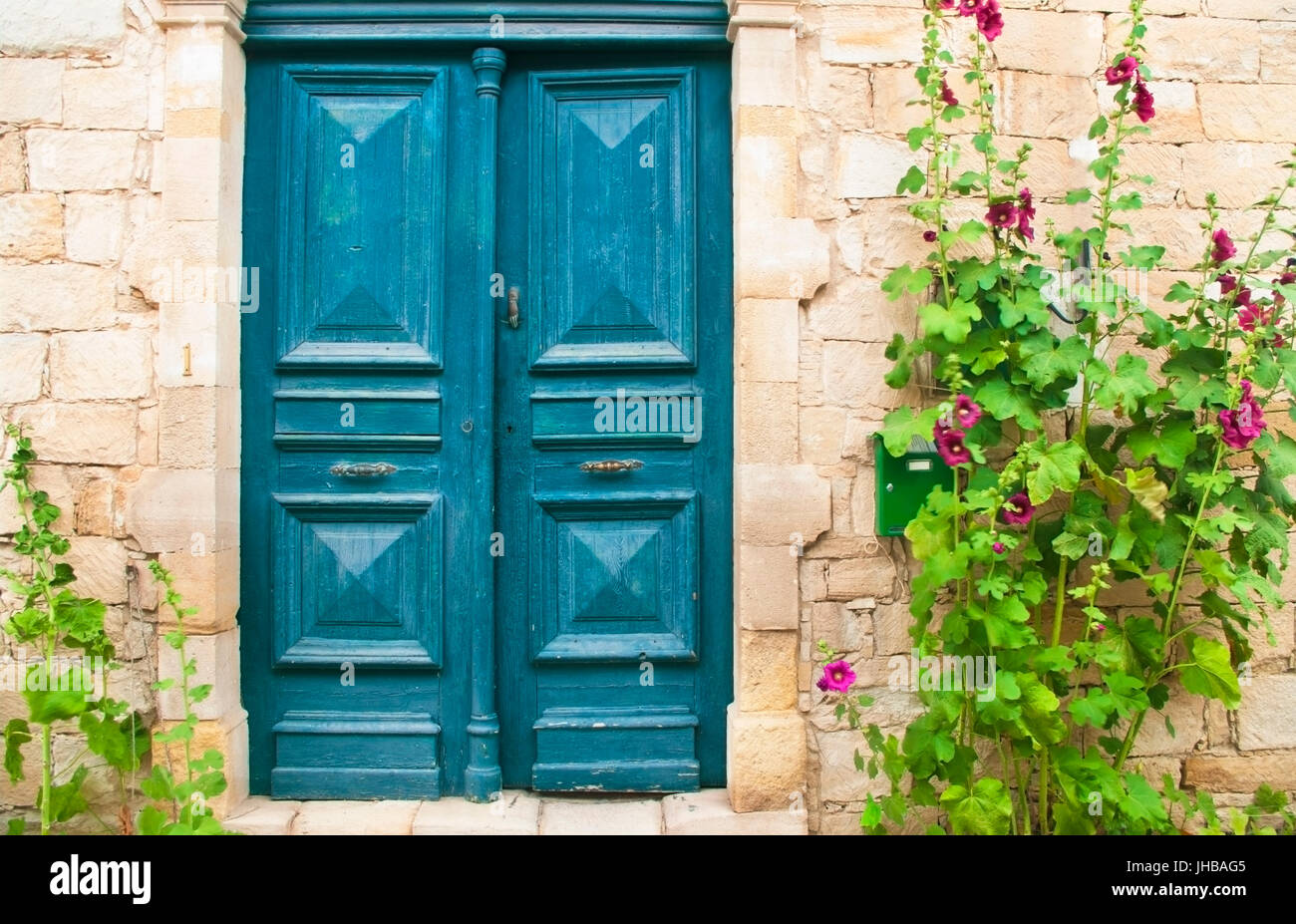 traditionellen zypriotischen Haustür mit blühenden Blumen malva Stockfoto