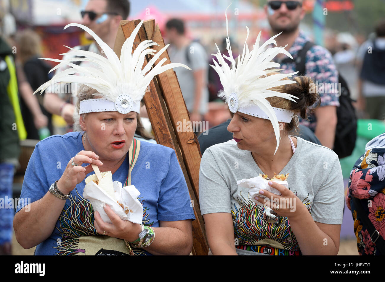 Menschen tragen Kopfschmuck Essen beim Glastonbury Festival, würdig Bauernhof, Somerset. PRESSEVERBAND Foto. Bild Datum: Sonntag, 25. Juni 2017. Bildnachweis sollte lauten: Ben Birchall/PA Wire Stockfoto