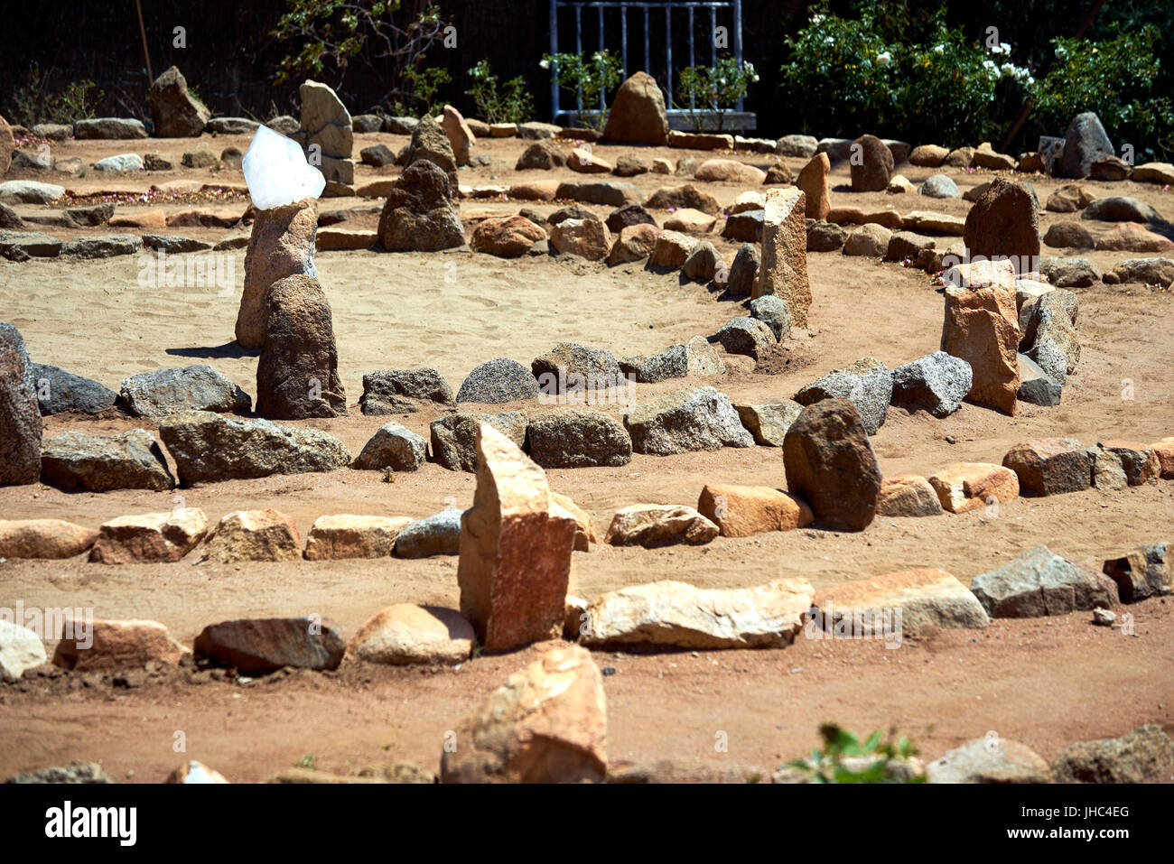 Großer Stein und Sand Labyrinth in Mitte Tag Sonnenlicht getaucht; Kristall Stein in Mitte um Ihre Gedanken zu sammeln Stockfoto