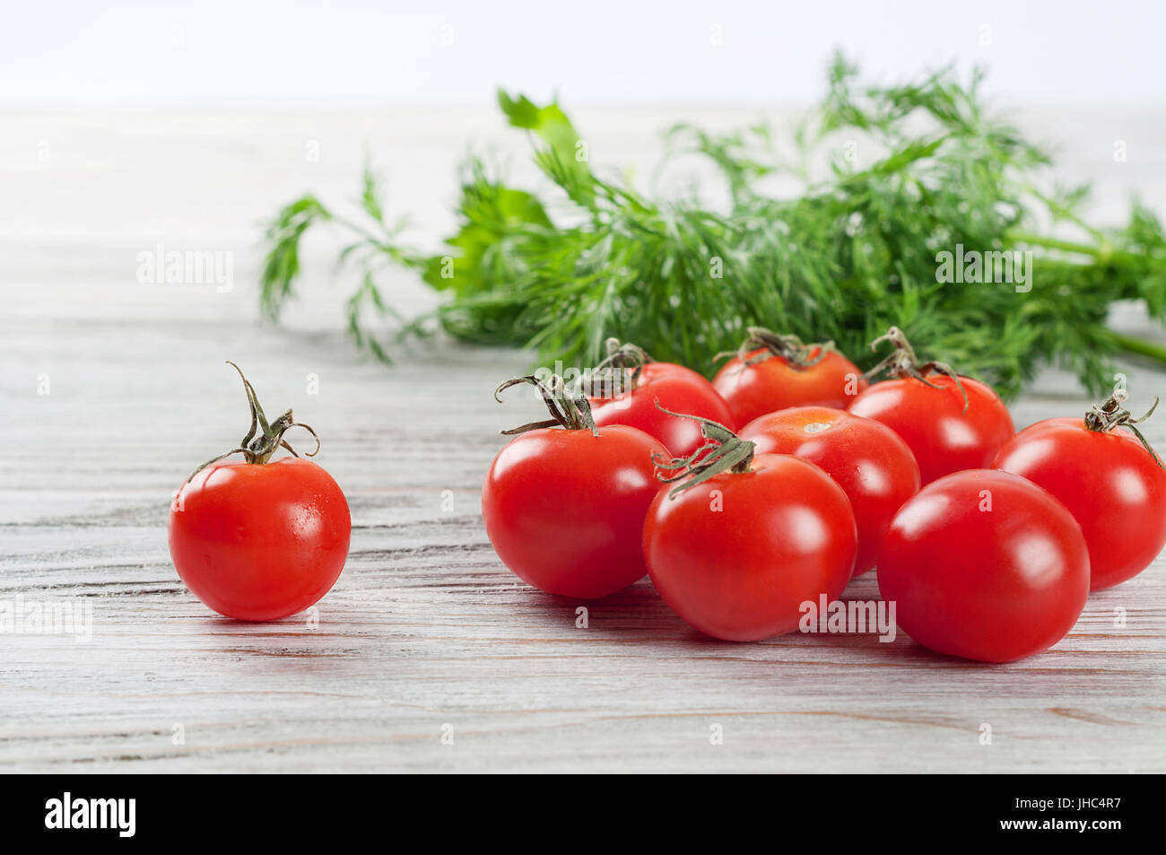 Rote, Reife Cherry-Tomaten und grünen Dill auf einem Holztisch Stockfoto