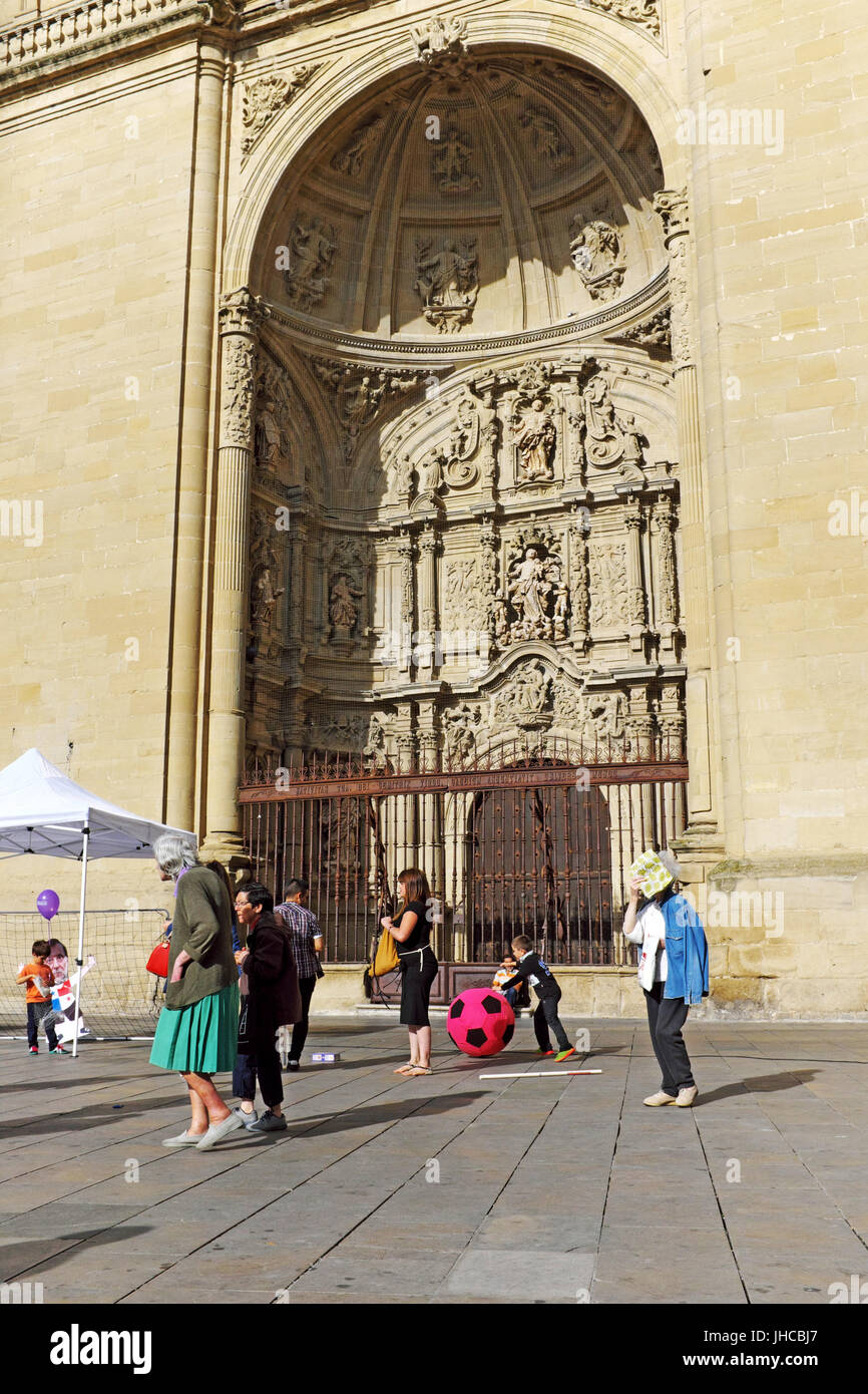 Der Portikus der Kathedrale Santa Maria de la Redonda befindet sich gegenüber der Plaza de Mercado in Logrono, Spanien, wo die Menschen in der Sommersonne im Juni spazieren oder spielen. Stockfoto