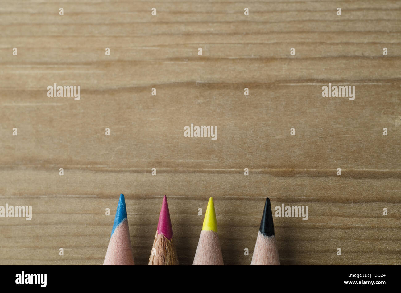 Tipps von vier Bleistifte, nach oben zeigend in kopieren Raum des hölzernen Hintergrund, repräsentieren das CMYK-Modell der Farbdruck. Stockfoto