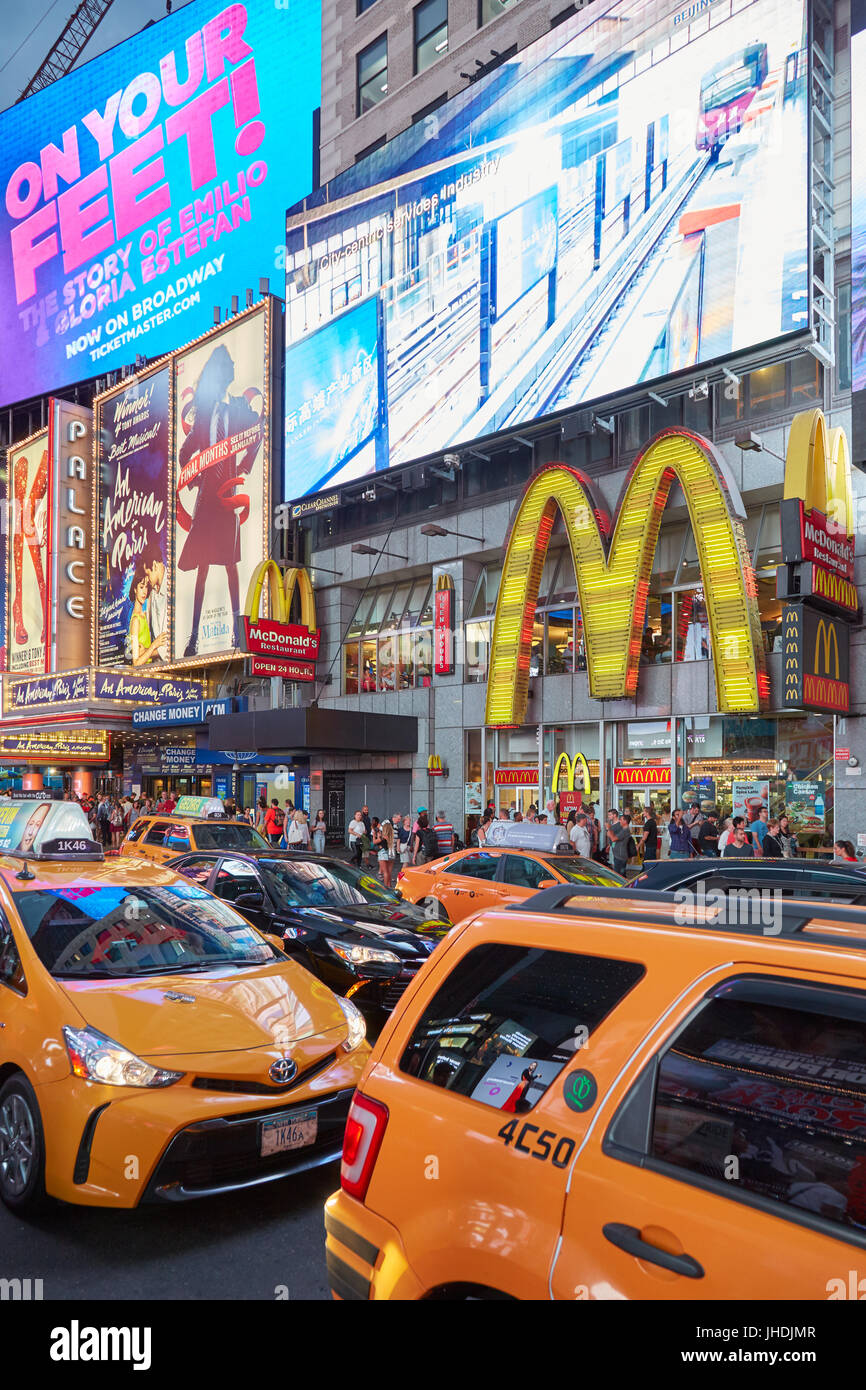 Der Times Square Show Plakate und Video Wall mit Menschen, gelbes Taxi Verkehr in der Nacht in New York Stockfoto