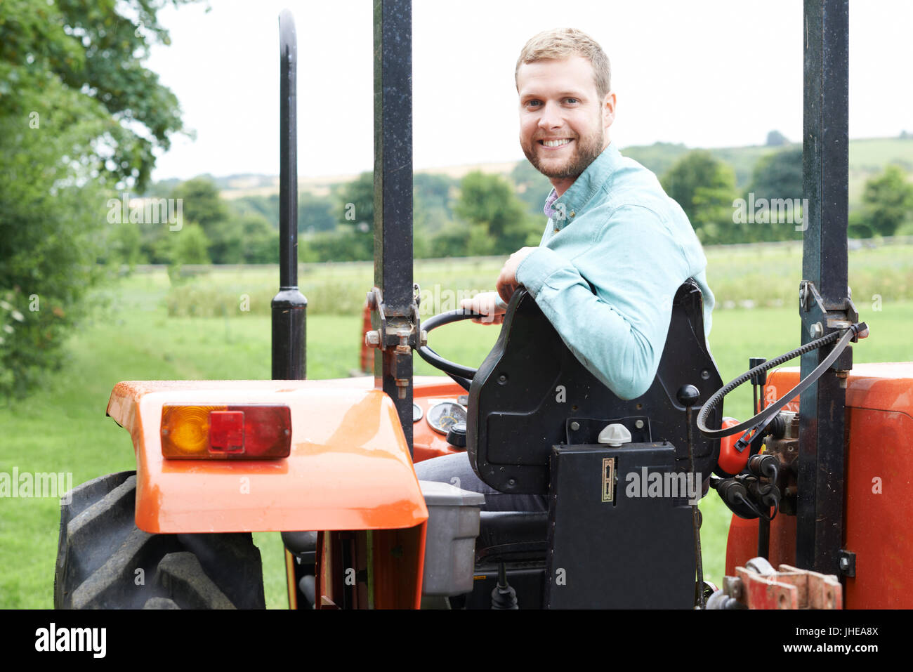 Porträt des Bauern sitzen auf Traktor im Feld Stockfoto