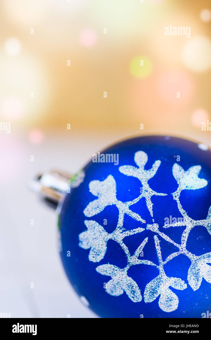 Blaue Weihnachtskugel mit weißen Schnee Flocke Ornament goldenen Hintergrund mit bunten Konfetti Fackel leuchten, Textfreiraum, Grußkarte Stockfoto