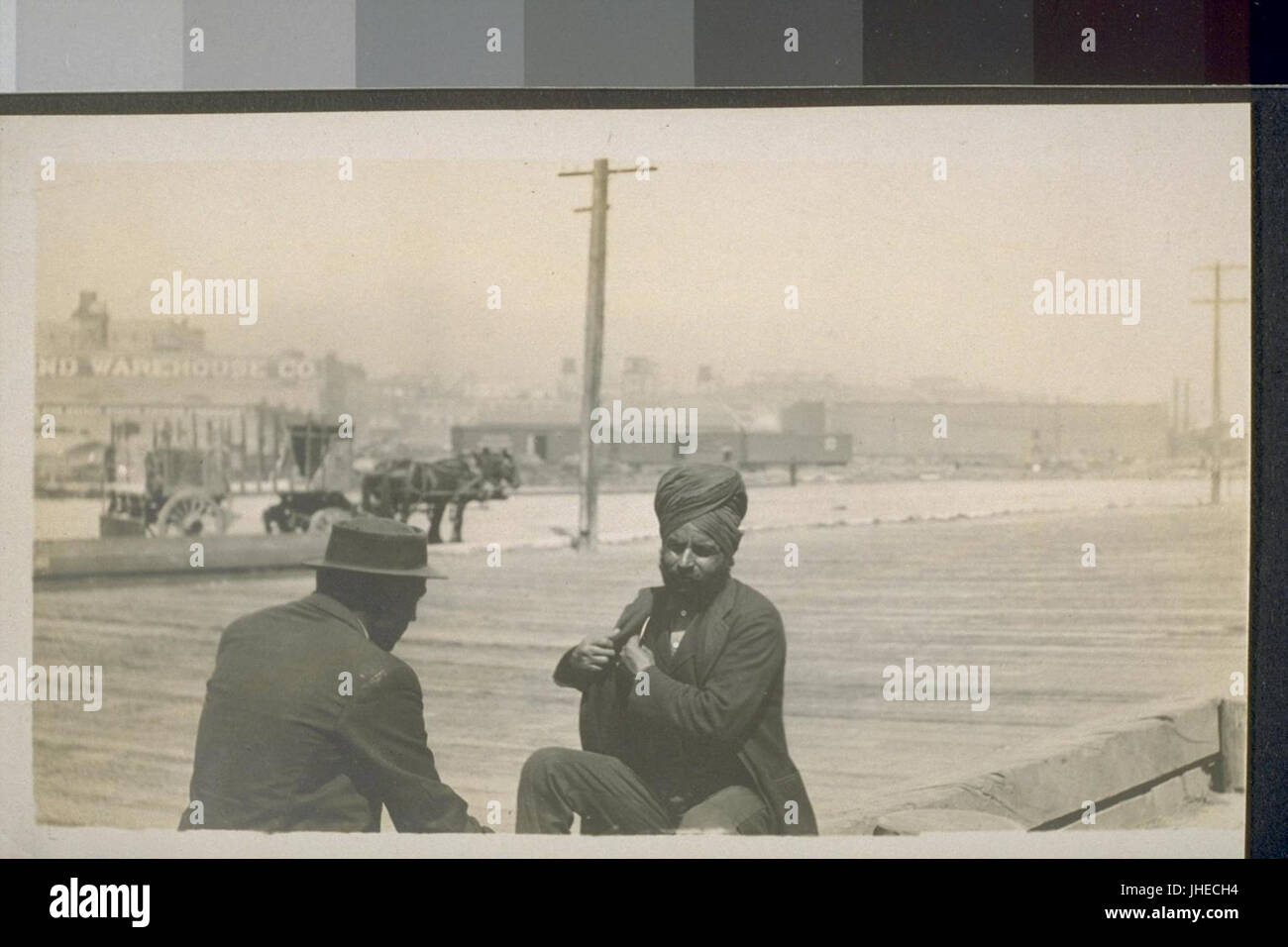 Männer sitzen auf einem hölzernen Bürgersteig in San Francisco (ca. 1910) Stockfoto