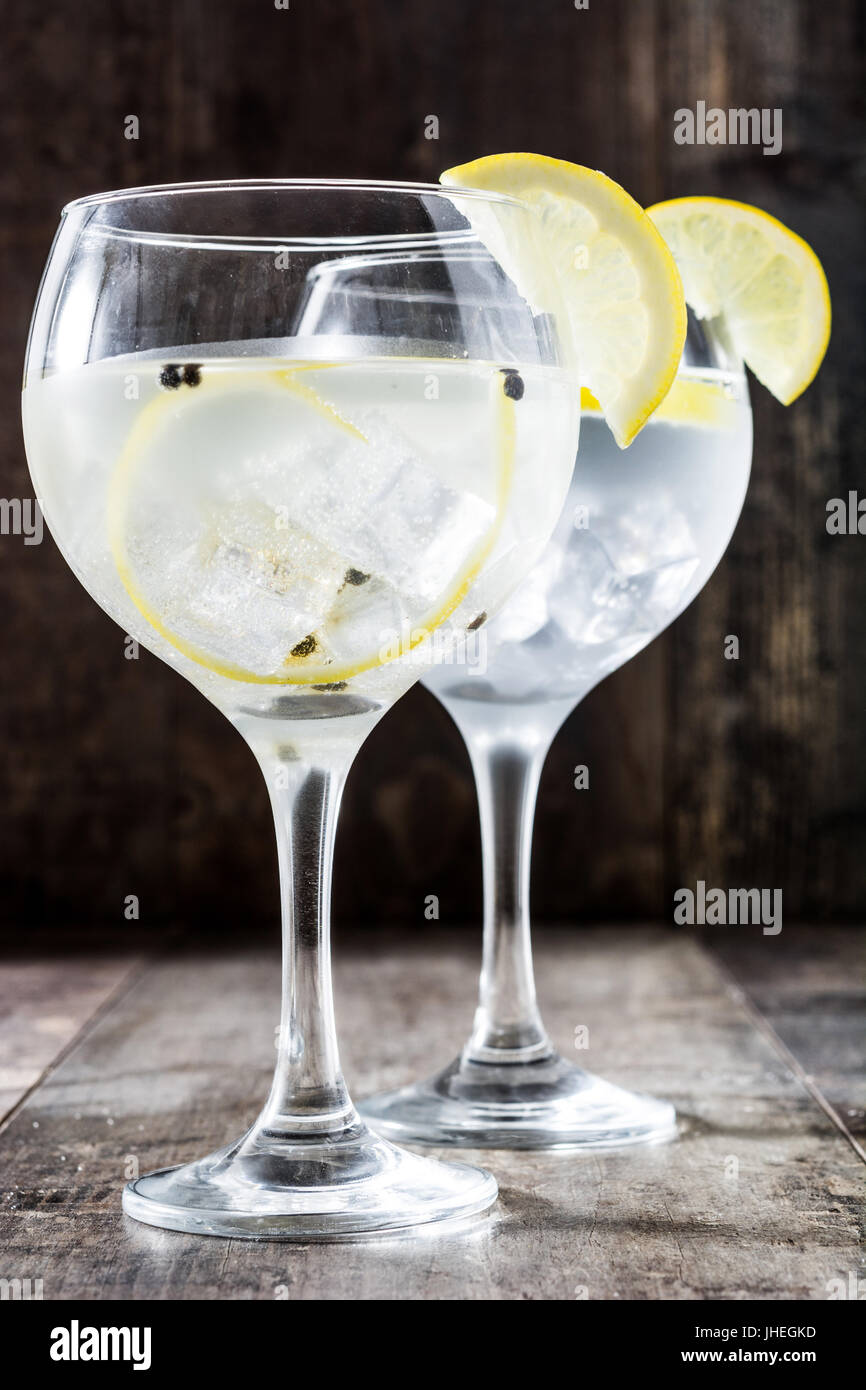 Glas von Gin Tonic mit Zitrone auf hölzernen Hintergrund Stockfoto
