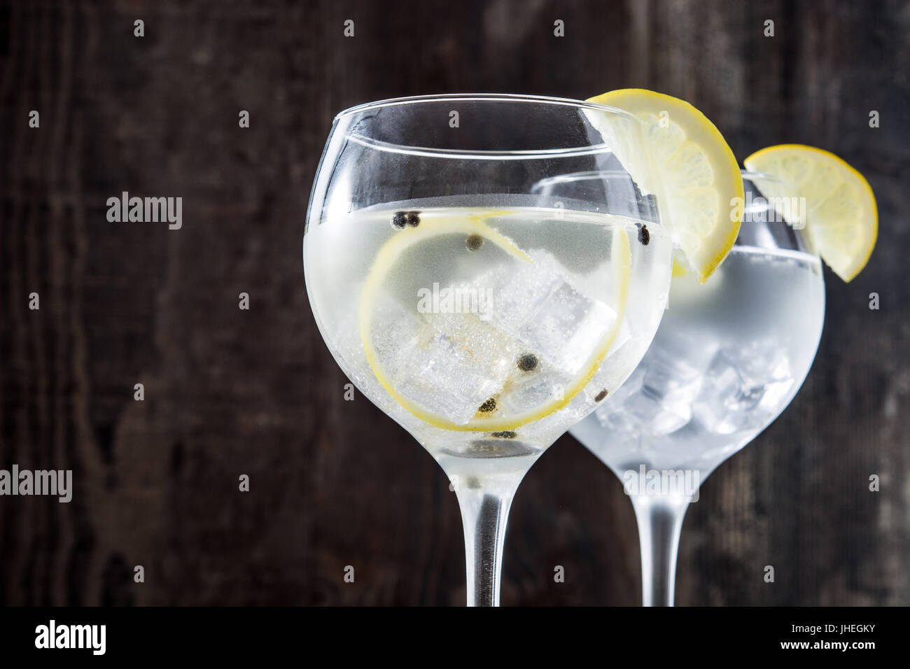 Glas von Gin Tonic mit Zitrone auf hölzernen Hintergrund Stockfoto