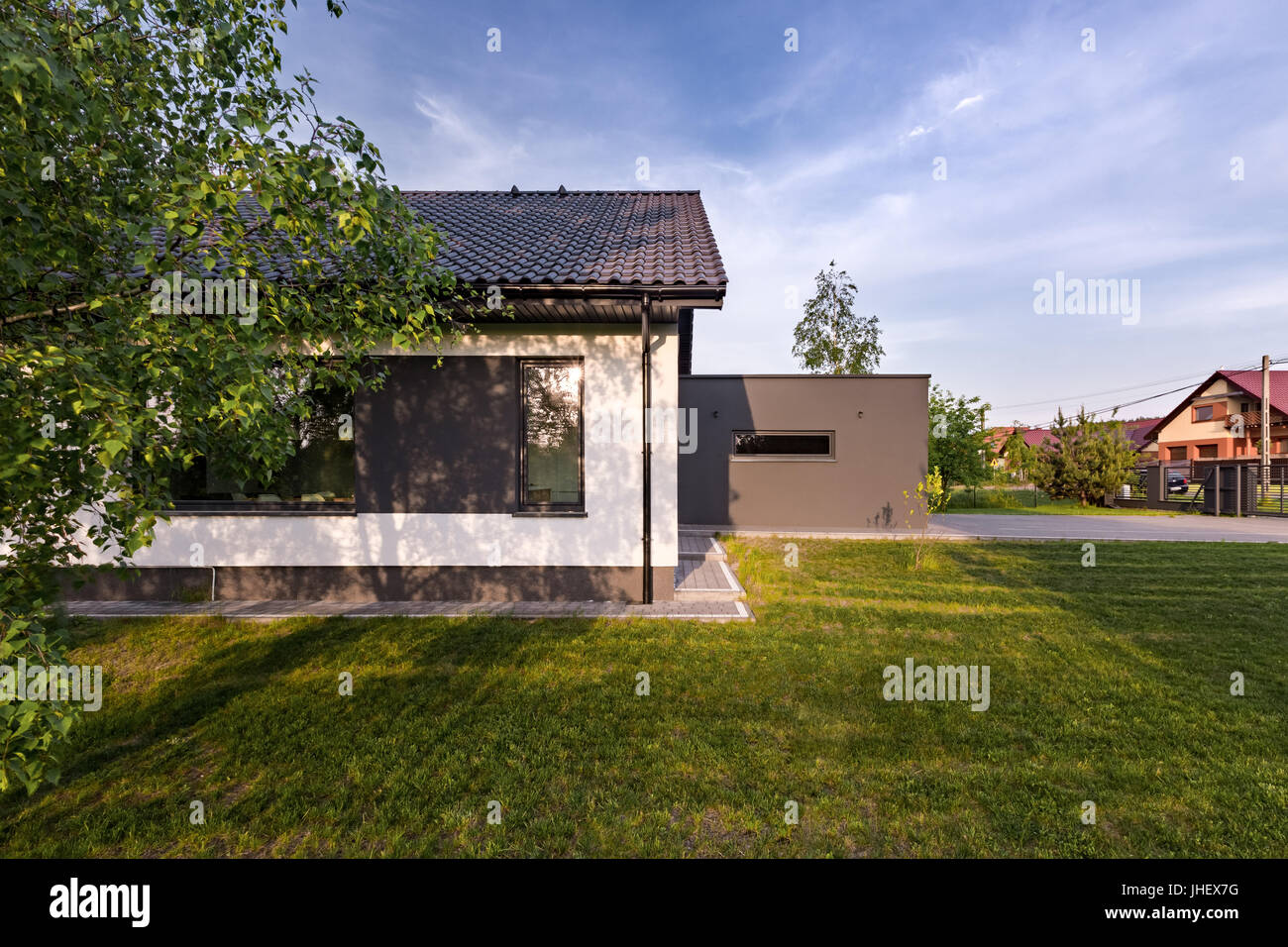 Außenansicht des einfachen weißen Haus mit großen grünen Rasen Stockfoto
