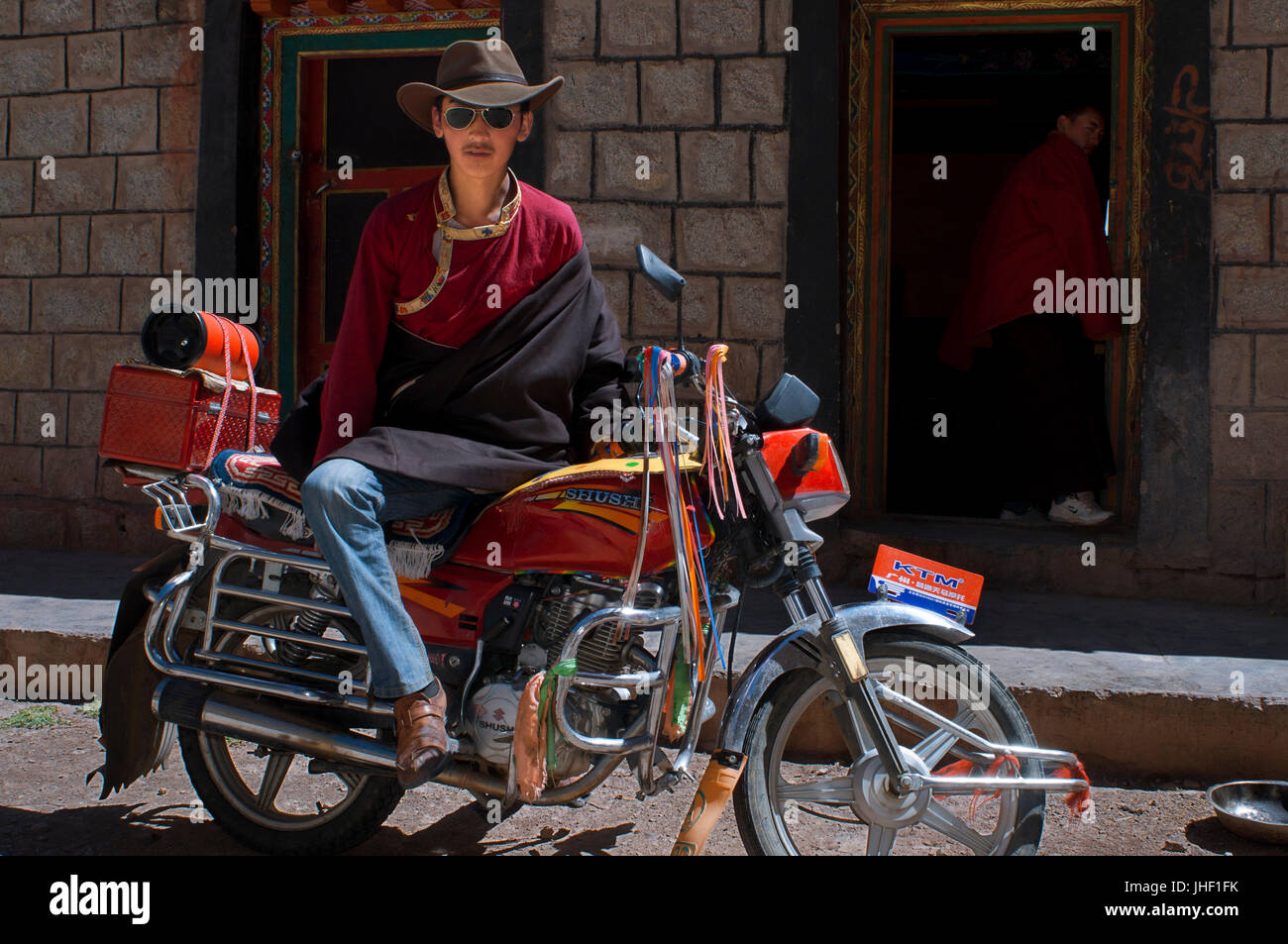 Einer der Mönche des Klosters Tasho Dor am südöstlichen Ende des Sees Nam Tso mit seinem Motorrad, Tibet. Stockfoto
