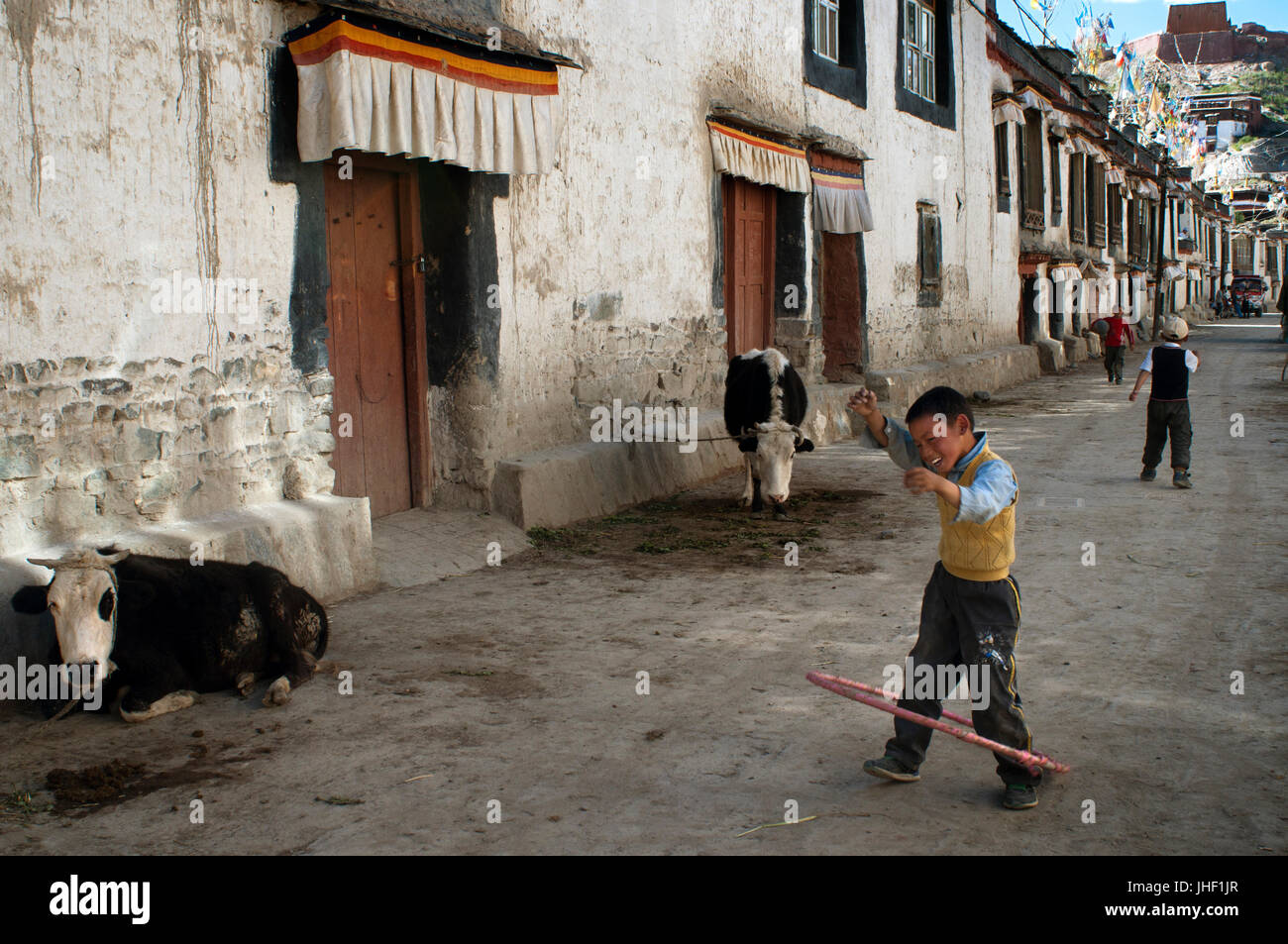 Zwei Kinder spielen in den Straßen der alten Stadt Gyantse. Gyantse Dorf, Tibet, China. Stockfoto