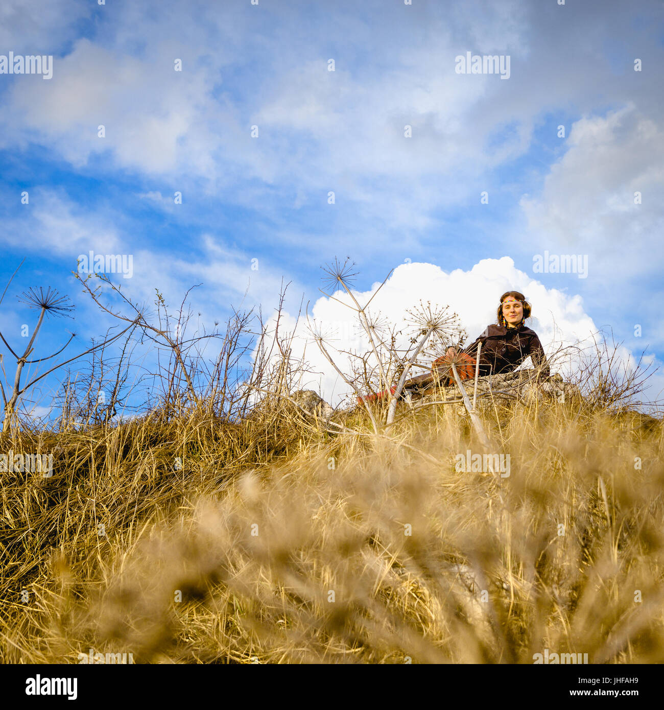 Frau auf dem Boden liegt auf einem Hügel gegen den Himmel und Wolken. Venera Göttin. Stockfoto