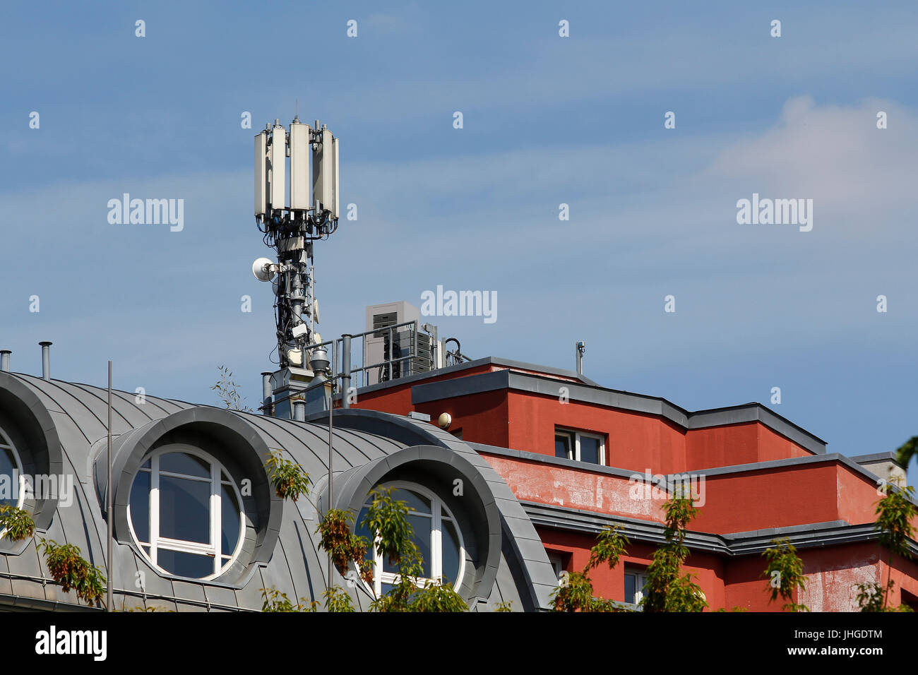 Mobile Antenne auf dem Dach eines Gebäudes gegen blauen Himmel Stockfoto