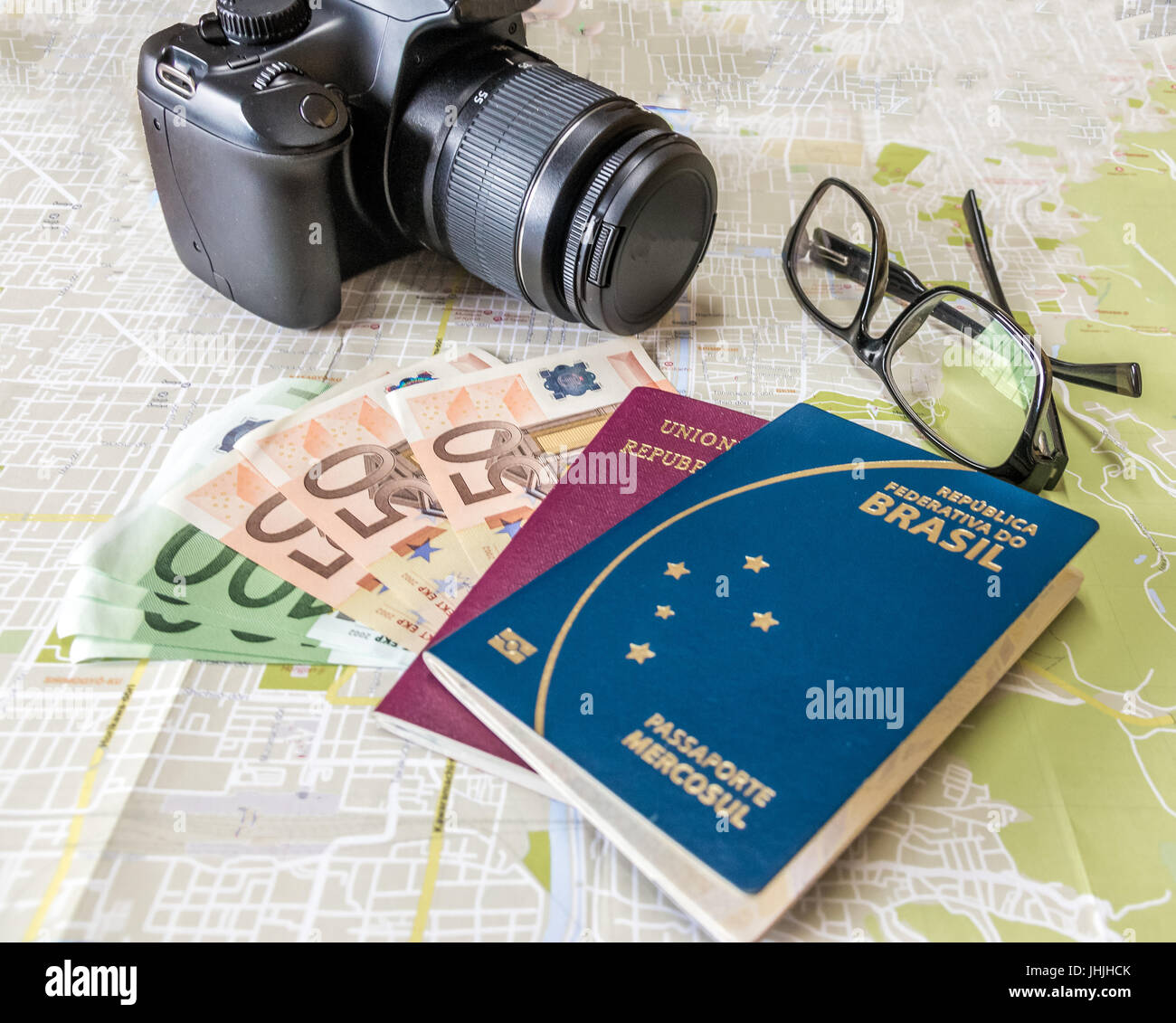 Planen Sie eine Reise - brasilianische und italienische Pässe auf Stadt Karte mit Euro Rechnungen Geld, Kamera und Gläser Stockfoto