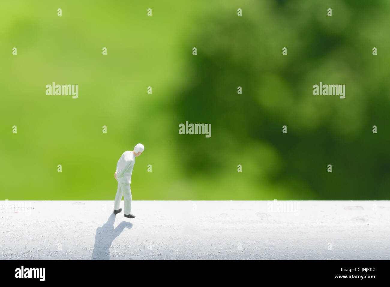 Geschäfts- und Finanzkonzept. Miniatur-Menschen: Unternehmer denken oder Entscheidung zu Fuß auf hohe weiße Wand mit grünen Natur Hintergrund Stockfoto