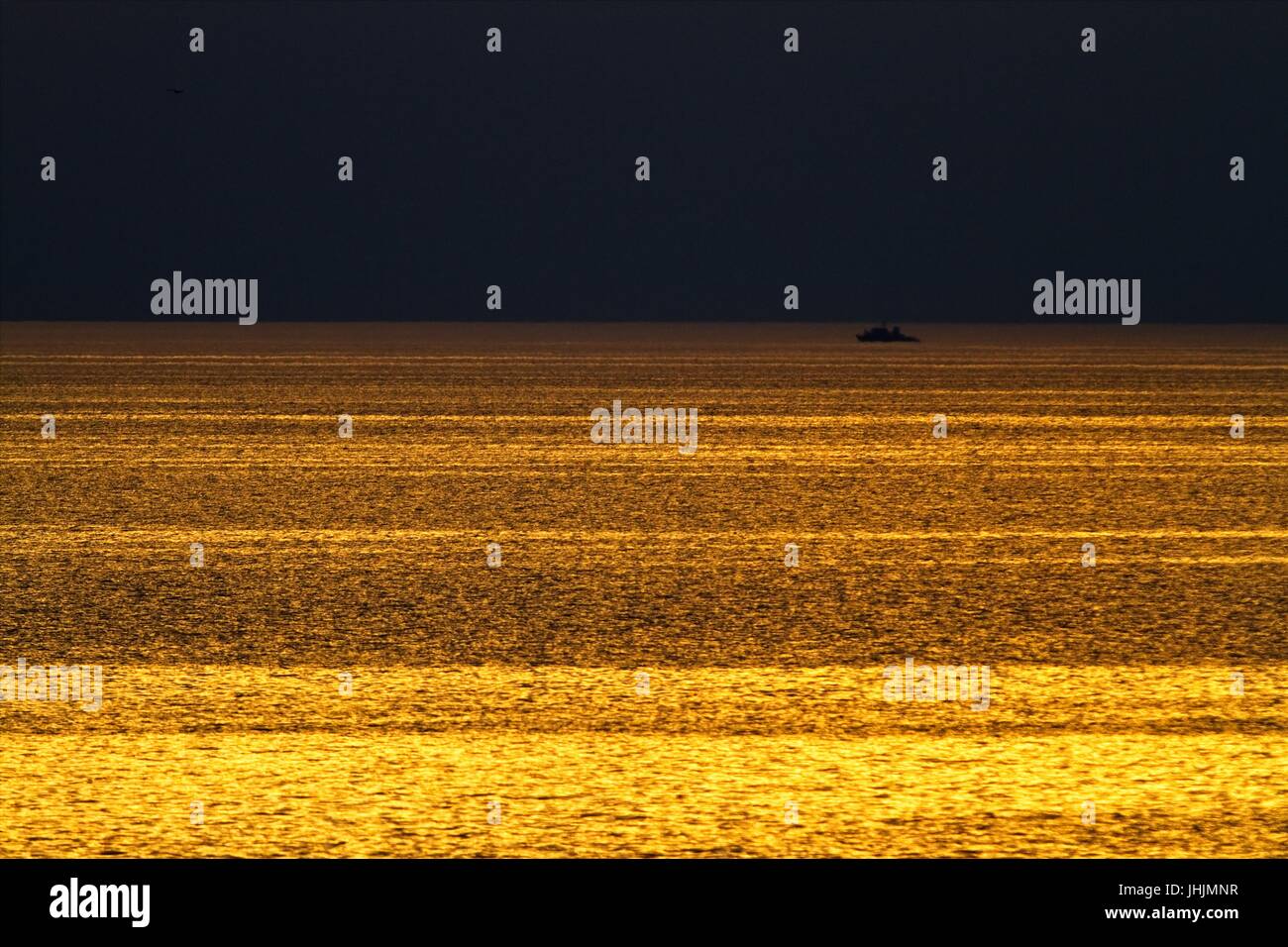 Goldener Sonnenuntergang. Am Meer. Silhouetten des Schlachtschiffes. Stockfoto