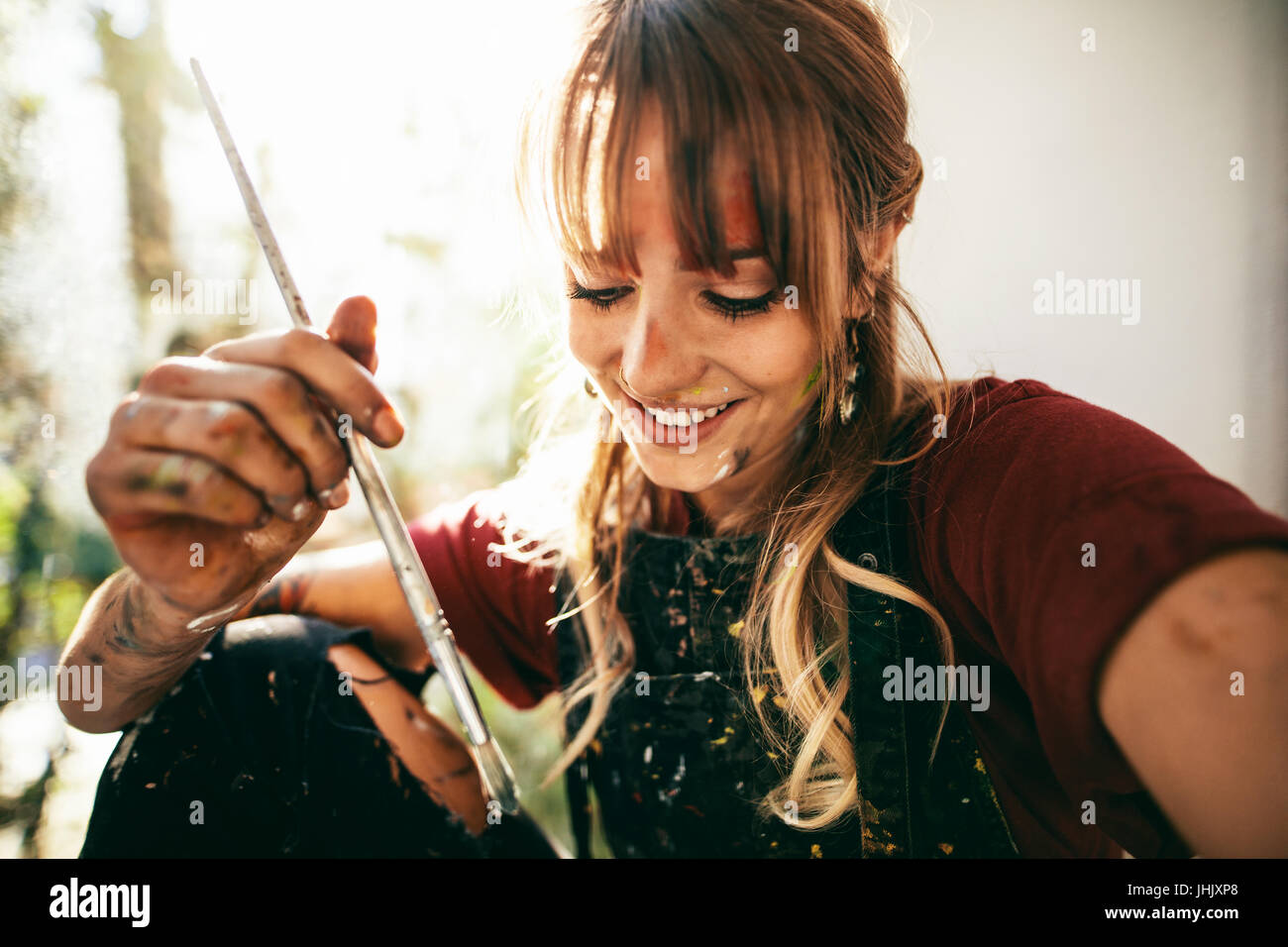 Nahaufnahme eines schönen jungen kaukasischen Frau Künstler mit Pinsel. Malerin Pinsel halten und Lächeln. Stockfoto