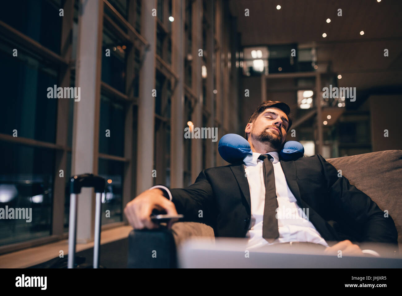 Reisende nach Flügen Verspätungen und Annullierungen am Flughafen warten. Geschäftsmann schlafend im Flughafen-Lounge. Stockfoto