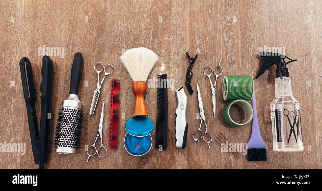 Professioneller Friseur-Tools auf der Holzoberfläche. Draufsicht der Friseur Zubehör in Linie angeordnet. Stockfoto