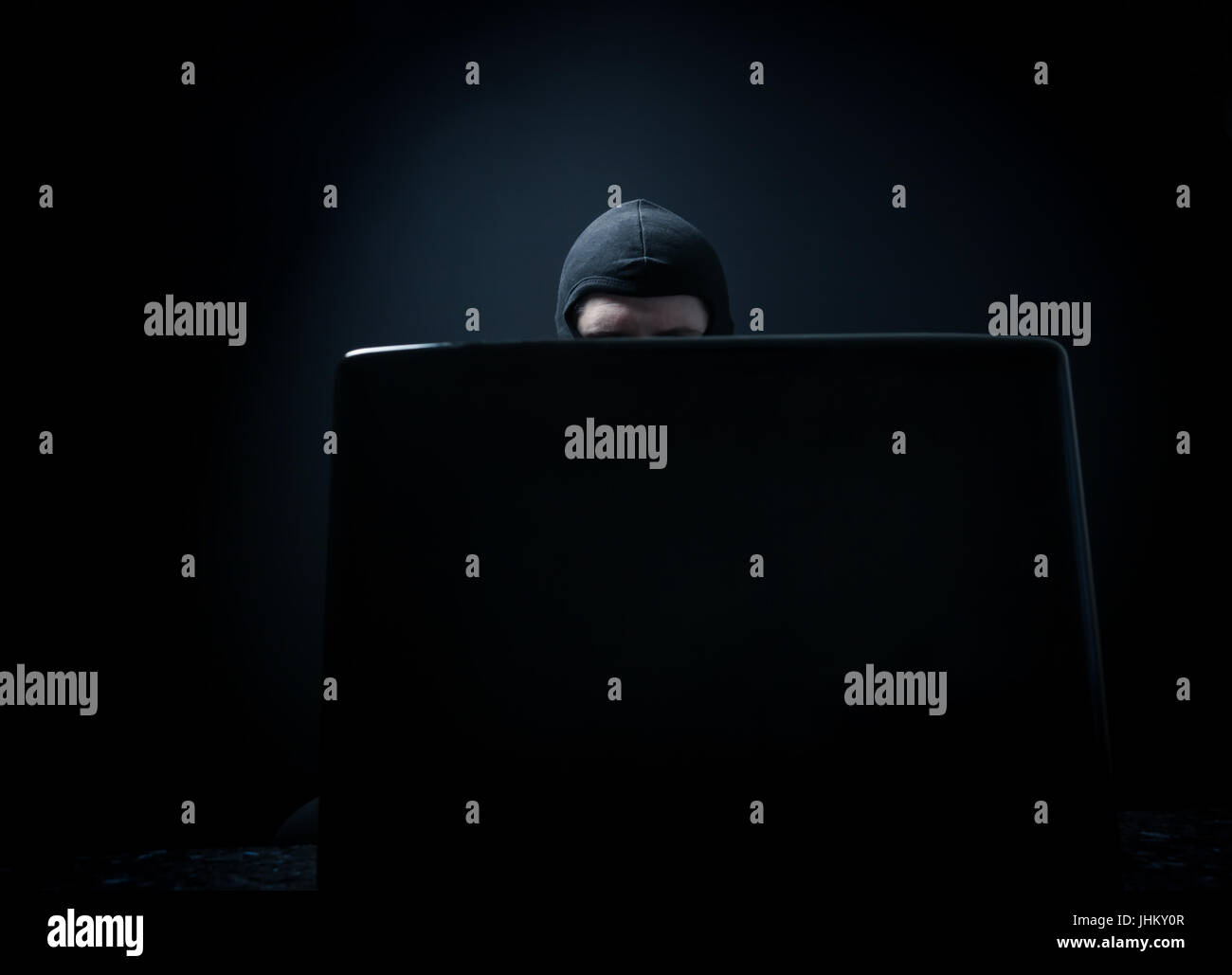 Wütend Geschäftsmann als Computer-Hacker im Anzug stehlen Daten von Laptop vor schwarzem Hintergrund Stockfoto