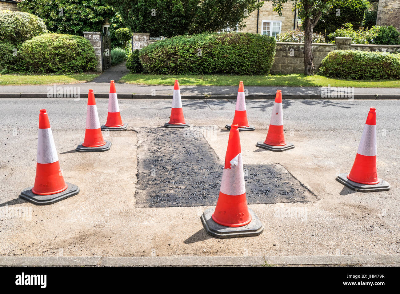 Kegel rund um neu verlegten Asphalt im Langtoft Dorf, Lincolnshire, England, UK. Stockfoto