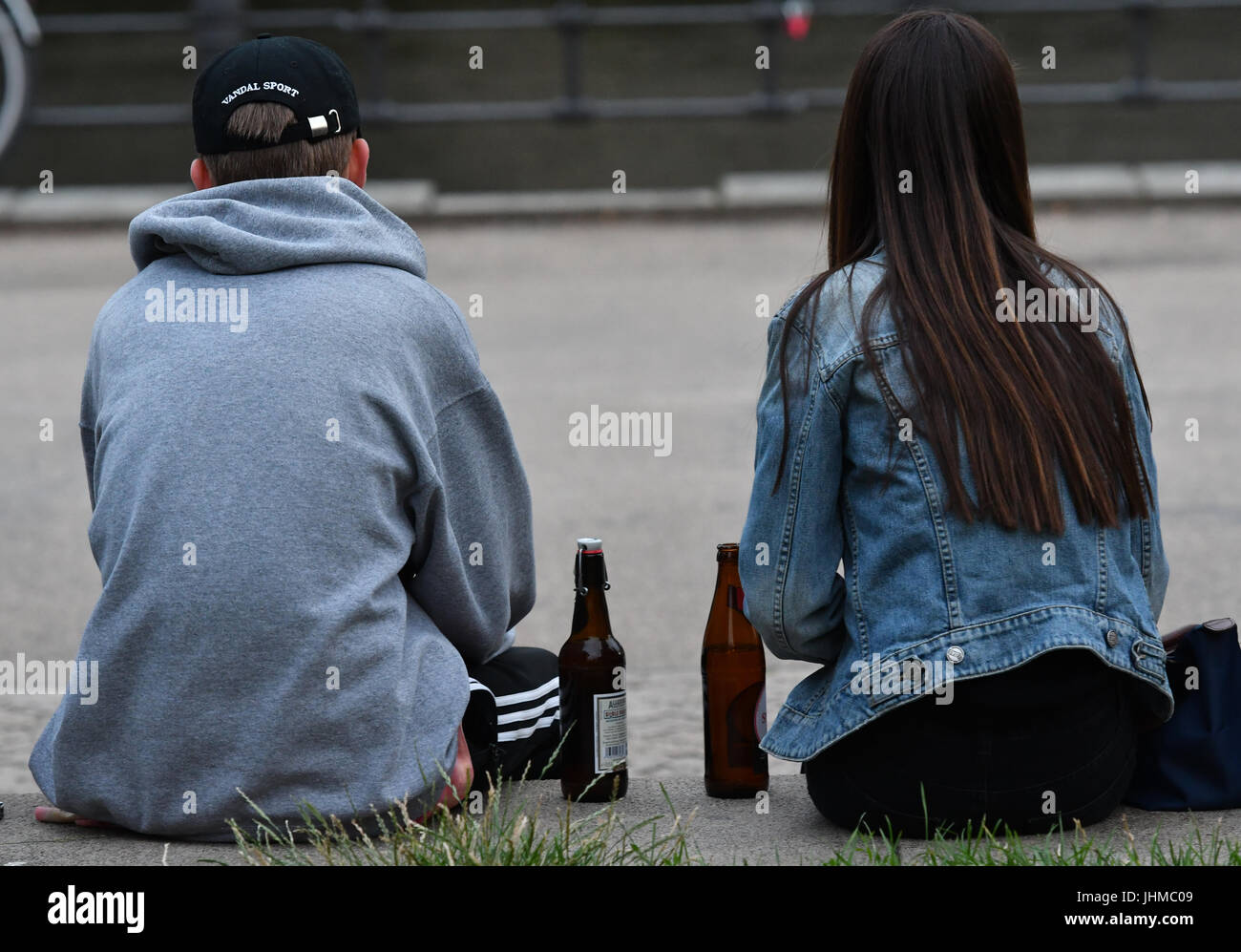 Berlin, Deutschland. 13. Juli 2017. Zwei junge Leute sitzen mit Bierflaschen in den frühen Abendstunden im Monbijoupark in Berlin, Deutschland, 13. Juli 2017. Foto: Paul Zinken/Dpa/Alamy Live News Stockfoto