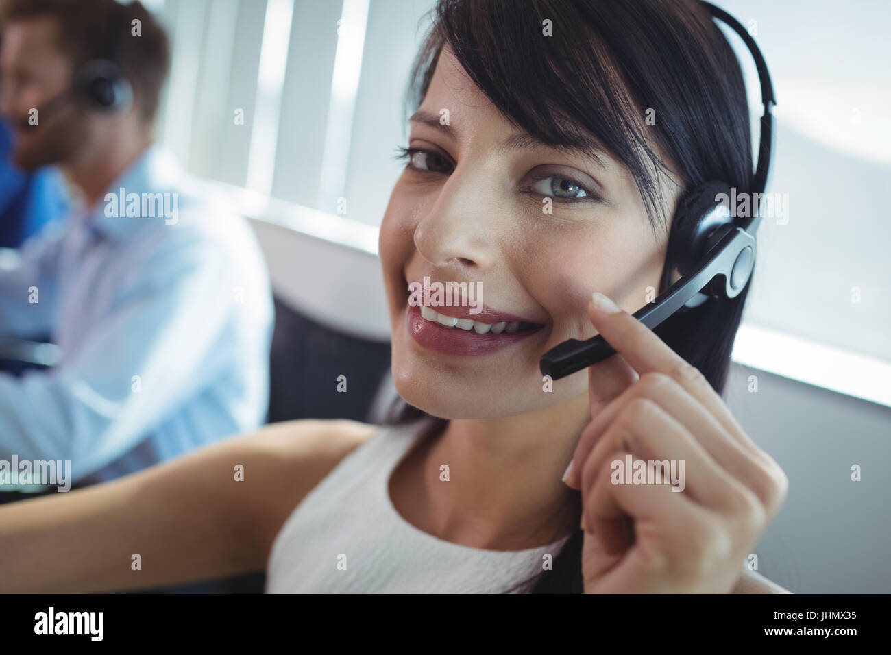 Porträt von lächelnden Geschäftsfrau mit Kopfhörer an Call-center Stockfoto